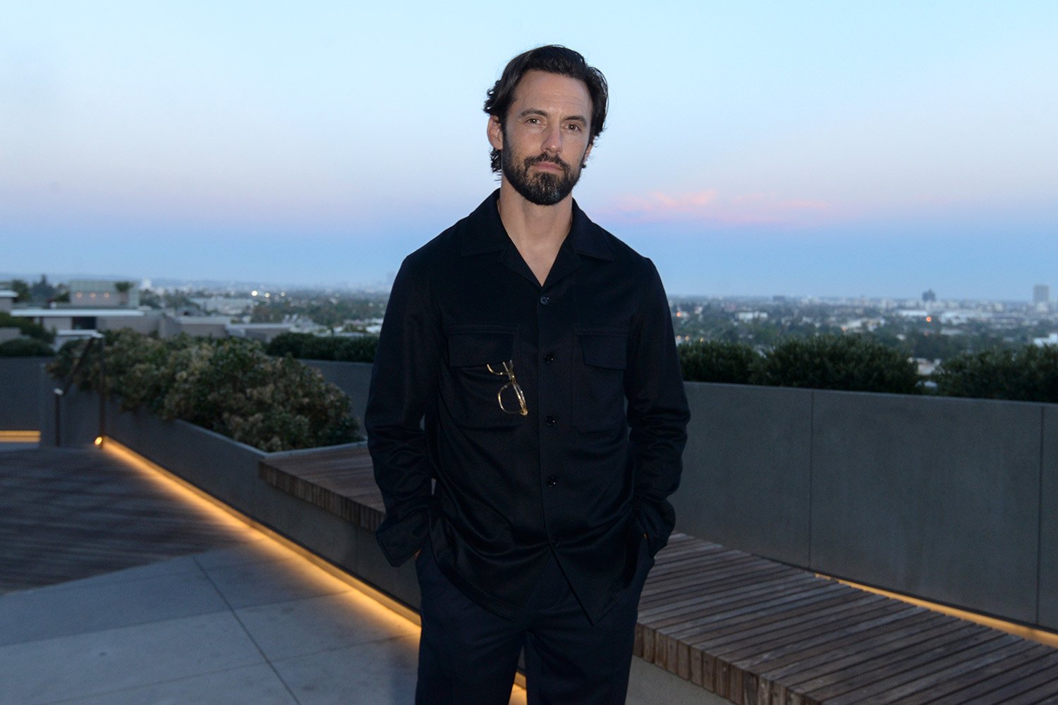 'Gilmore Girls' star Milo Ventimiglia dressed in black standing outside with his hands in his pockets