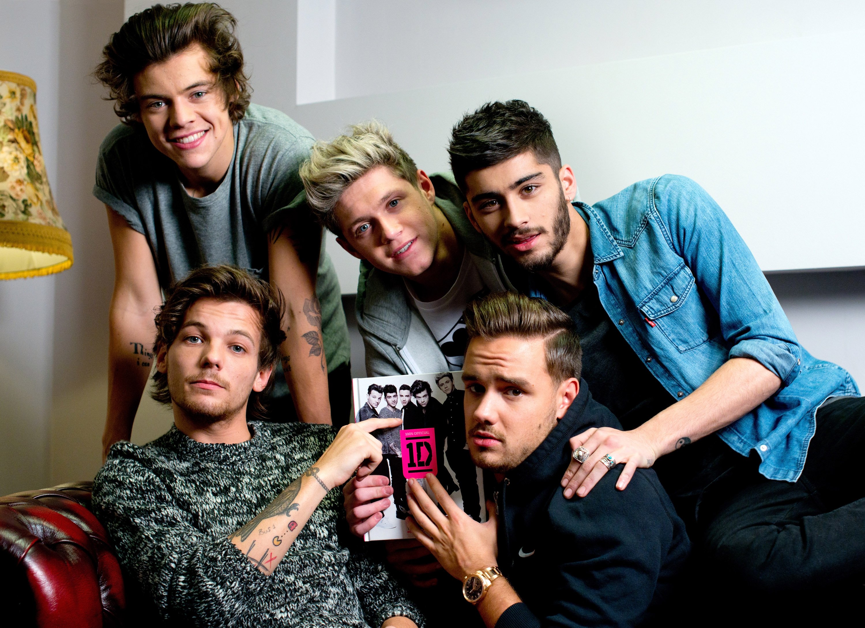 One Direction's Harry Styles, Louis Tomlinson, Niall Horan, Liam Payne, and Zayn Malik with a book