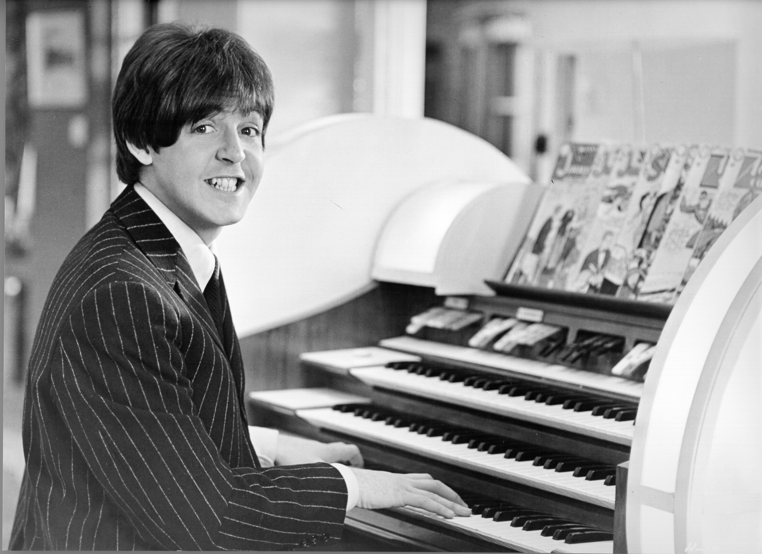 The Beatles' Paul McCartney sitting at a piano