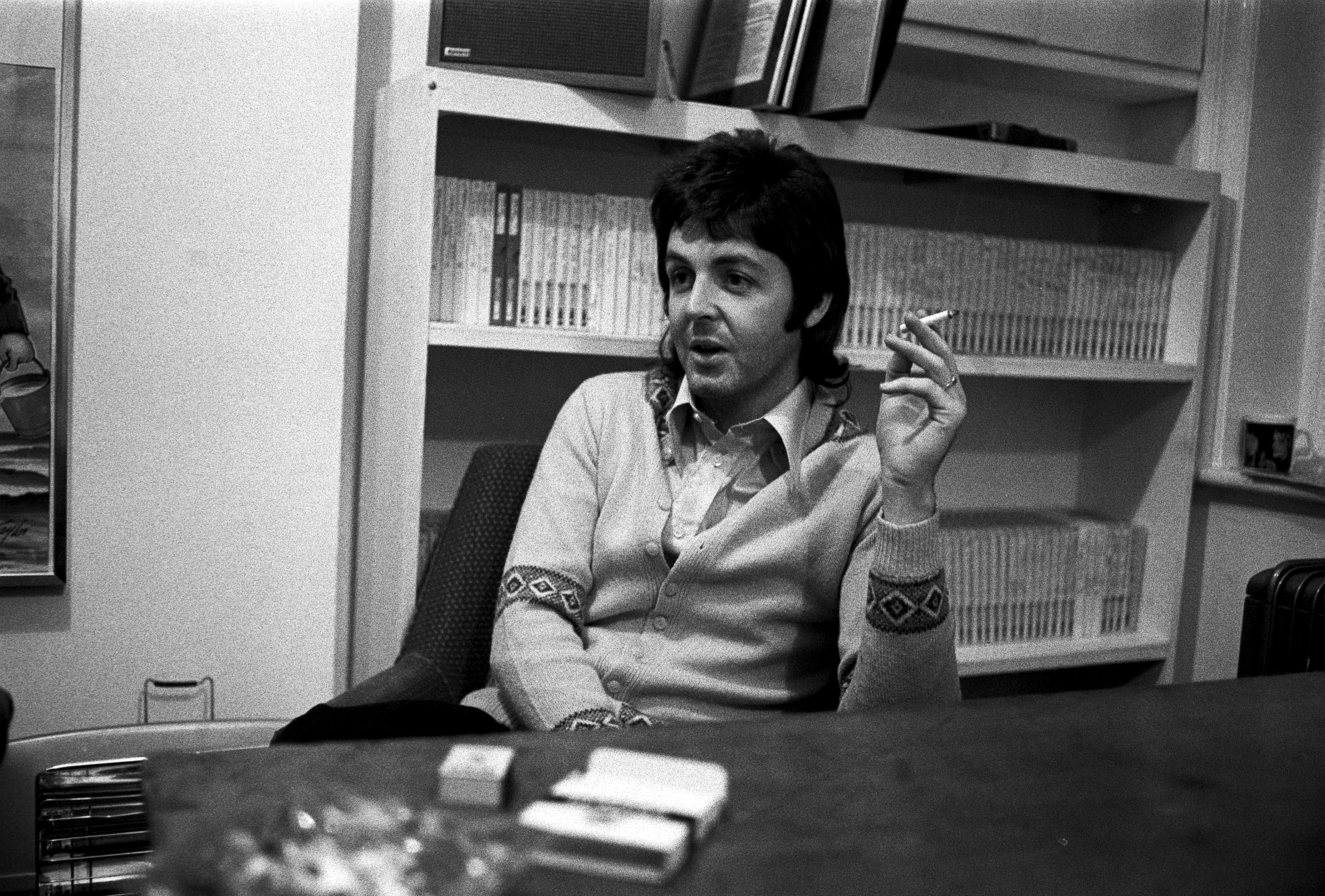 Paul McCartney in front of a bookshelf