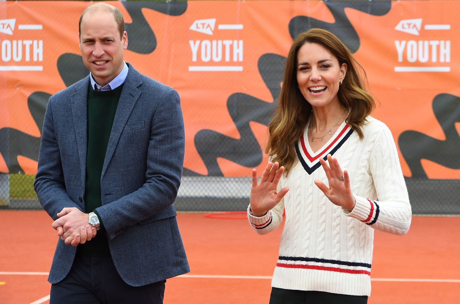 Prince William walks next to Kate Middleton as she smiles and waves