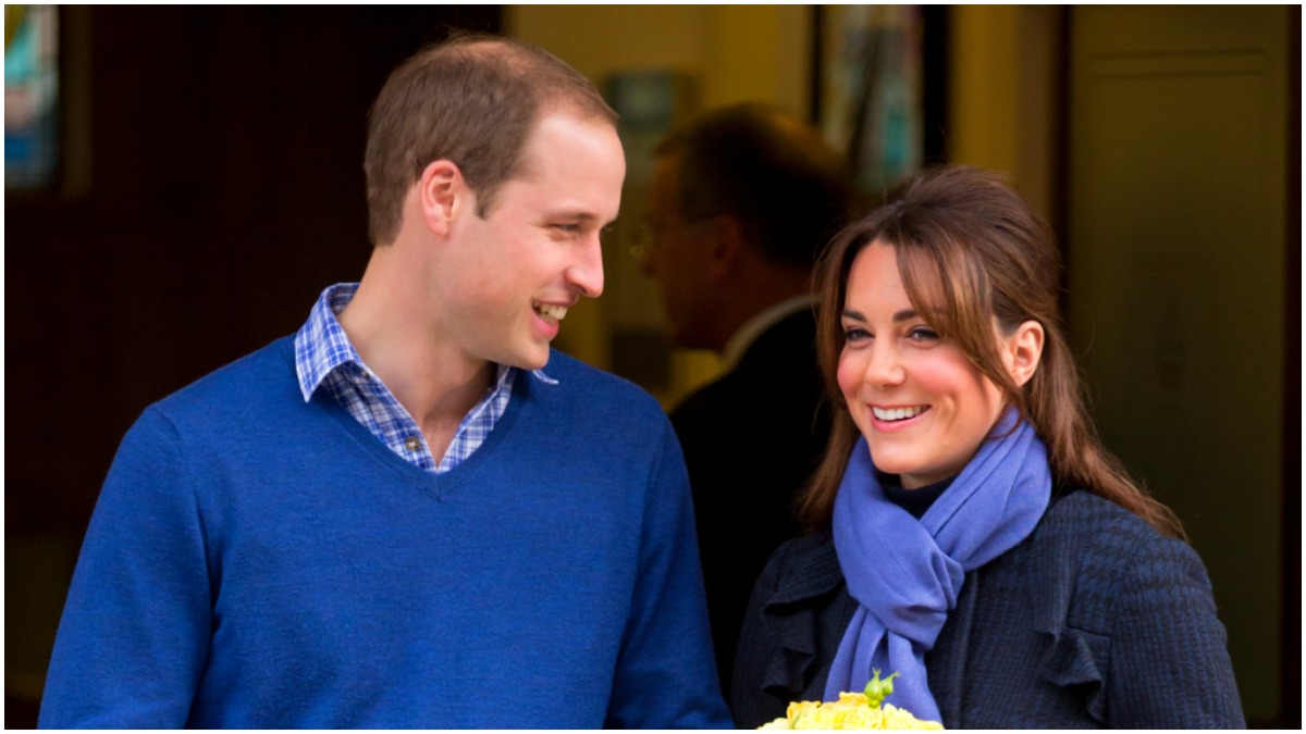 Prince William and Kate Middleton smile at one another as she holds flowers.