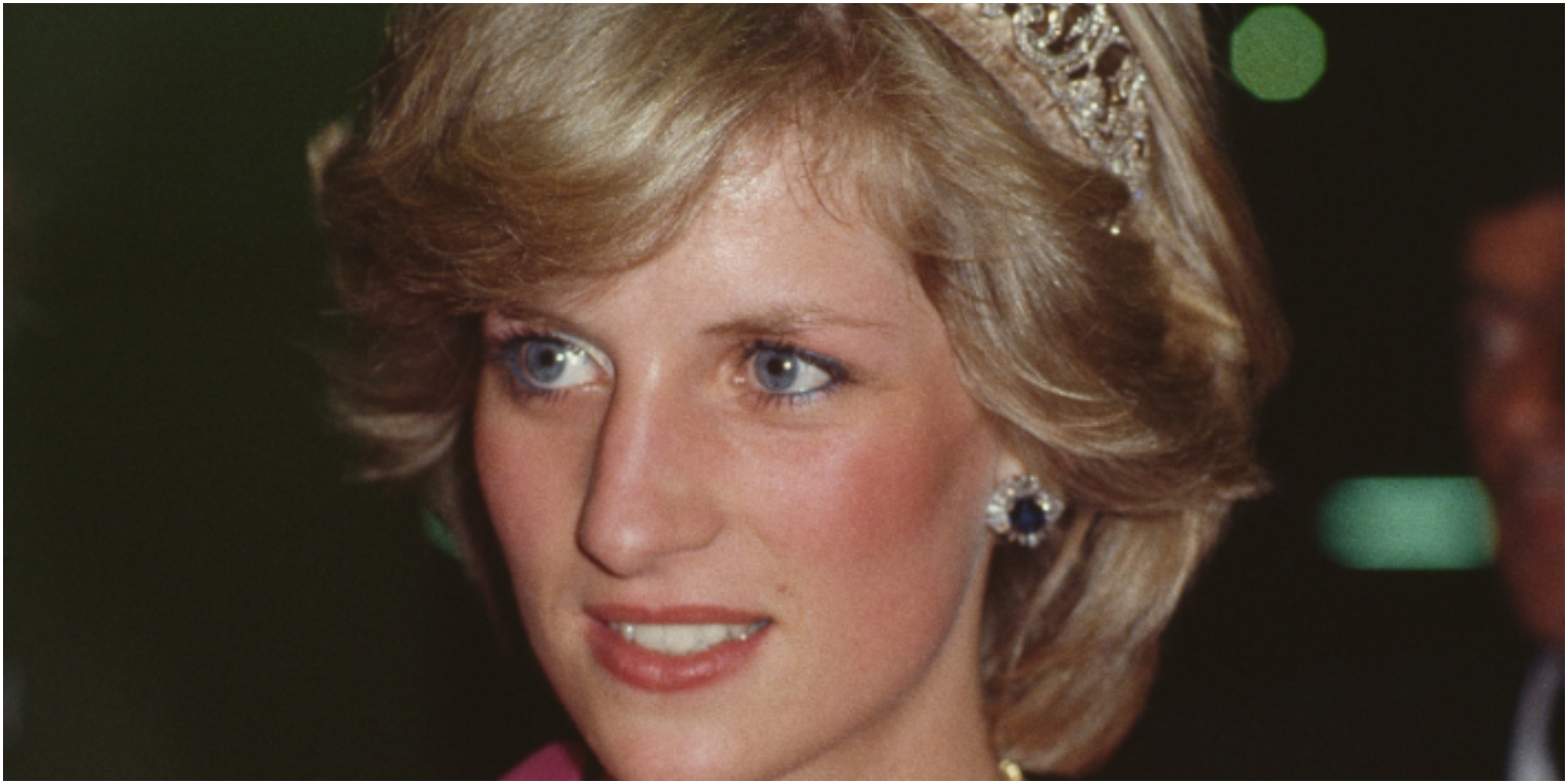 Princess Diana wears a blush colored gown and a crown.