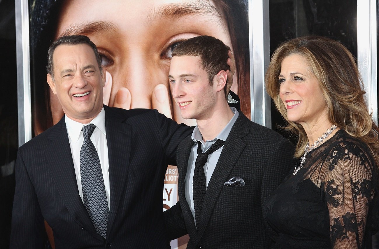 Tom Hanks, Chet Hanks, and Rita Wilson in 2011 -- Tom Hanks holds Chet Hanks' head while laughing at the camera -- Chet and Rita are smiling and looking to the side.