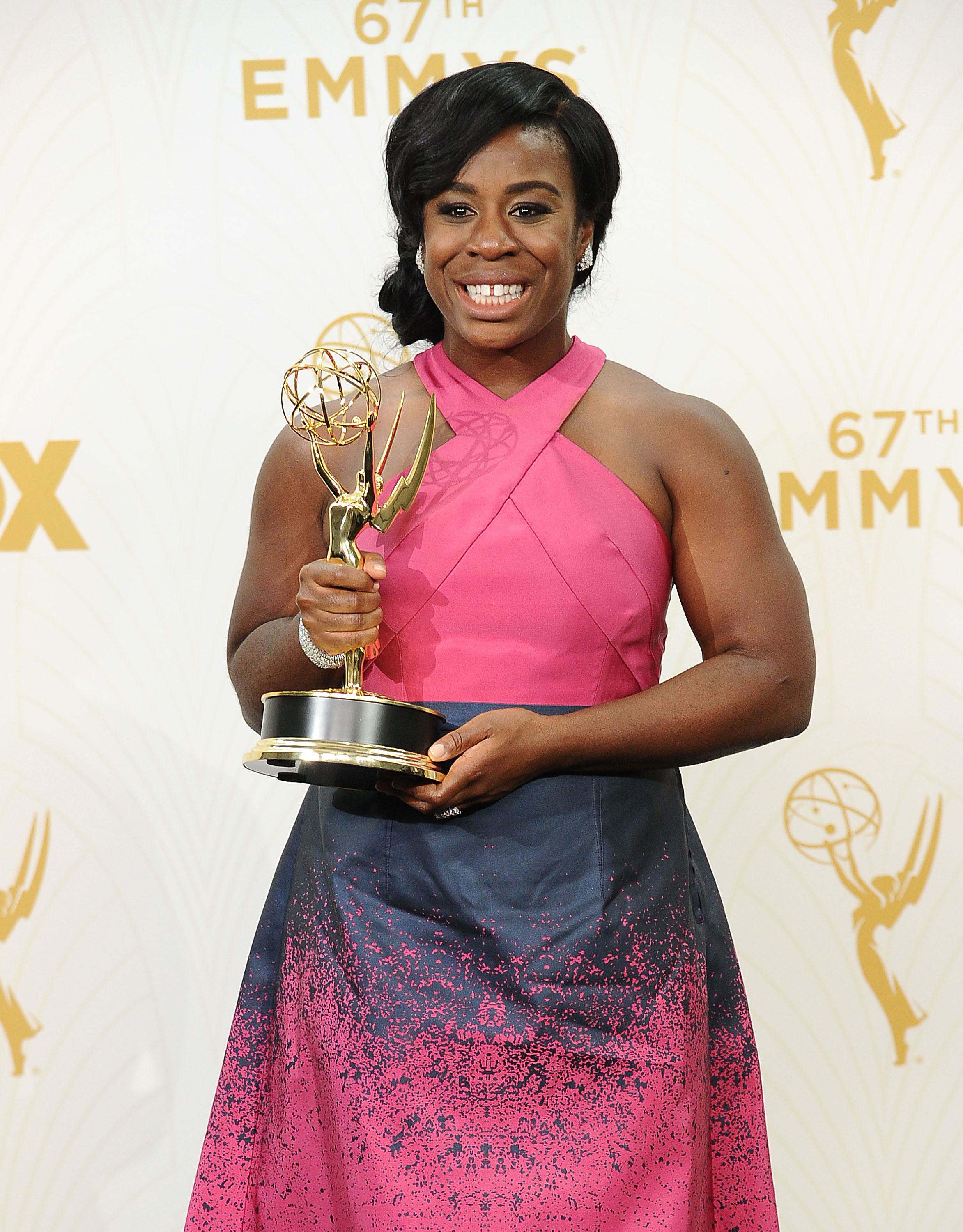 Uzo Aduba smiling and holding an Emmy award in 2015