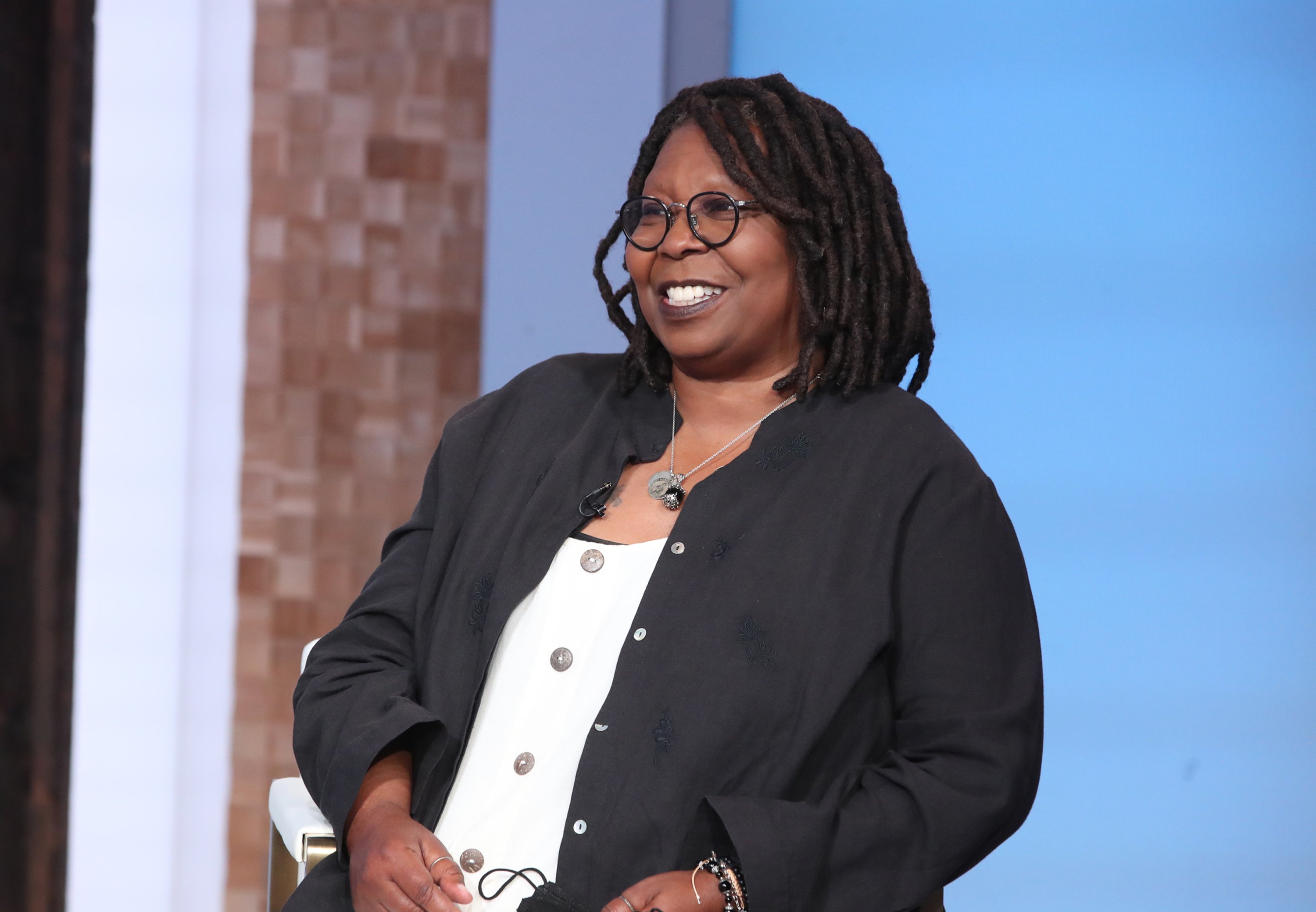 Whoopi Goldberg sits back and smiles on the set of 'Good Morning America'