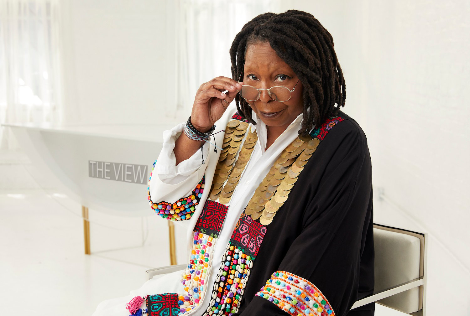 Whoopi Goldberg looks over her glasses while sitting down on the set of 'The View'