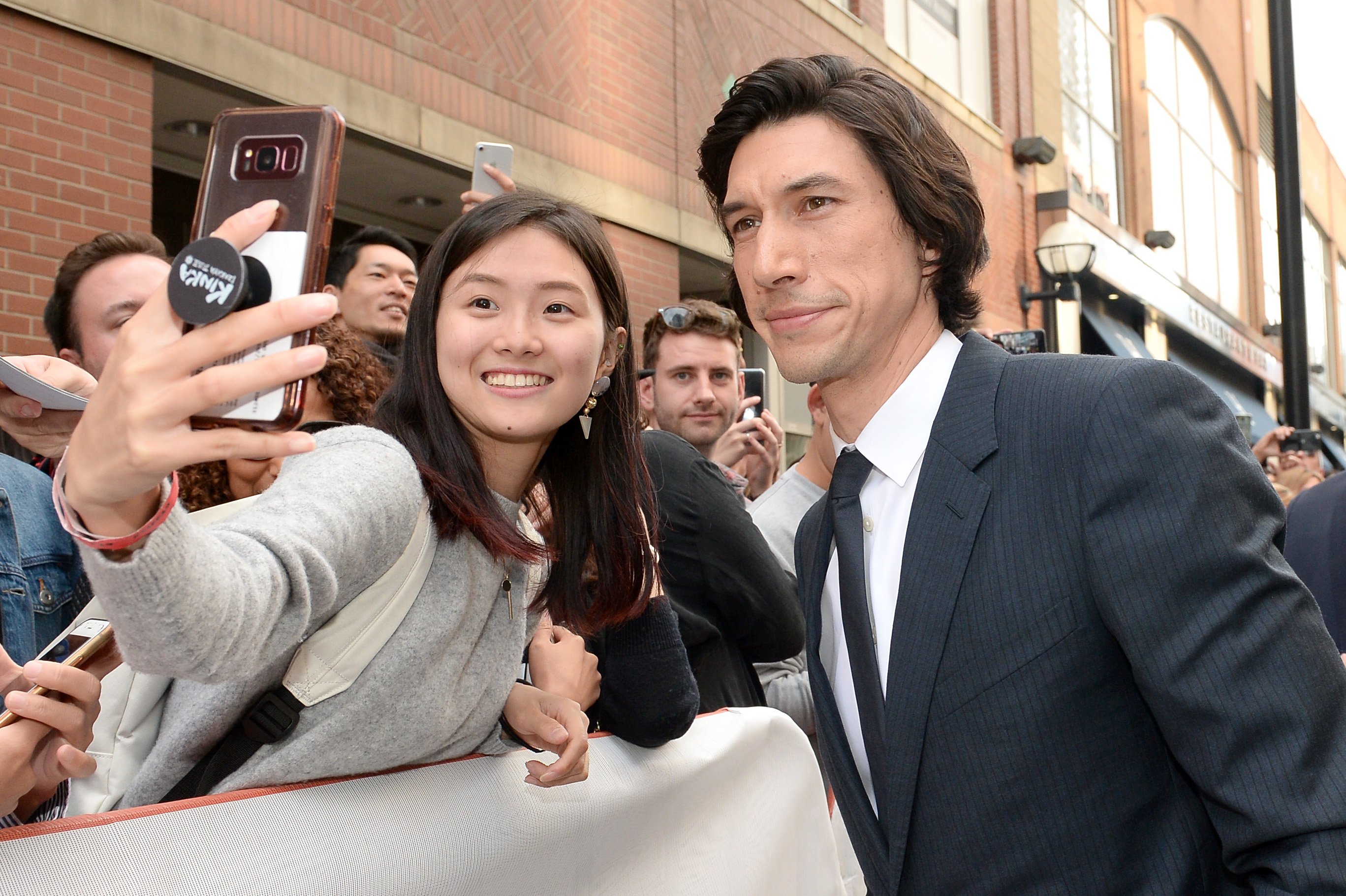 Adam Driver poses for a picture with a fan