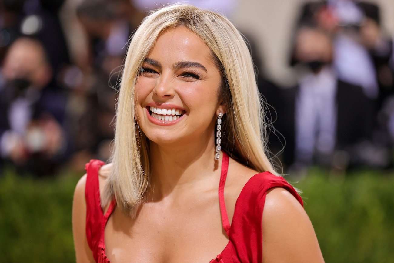 Addison Rae laughing in a red dress