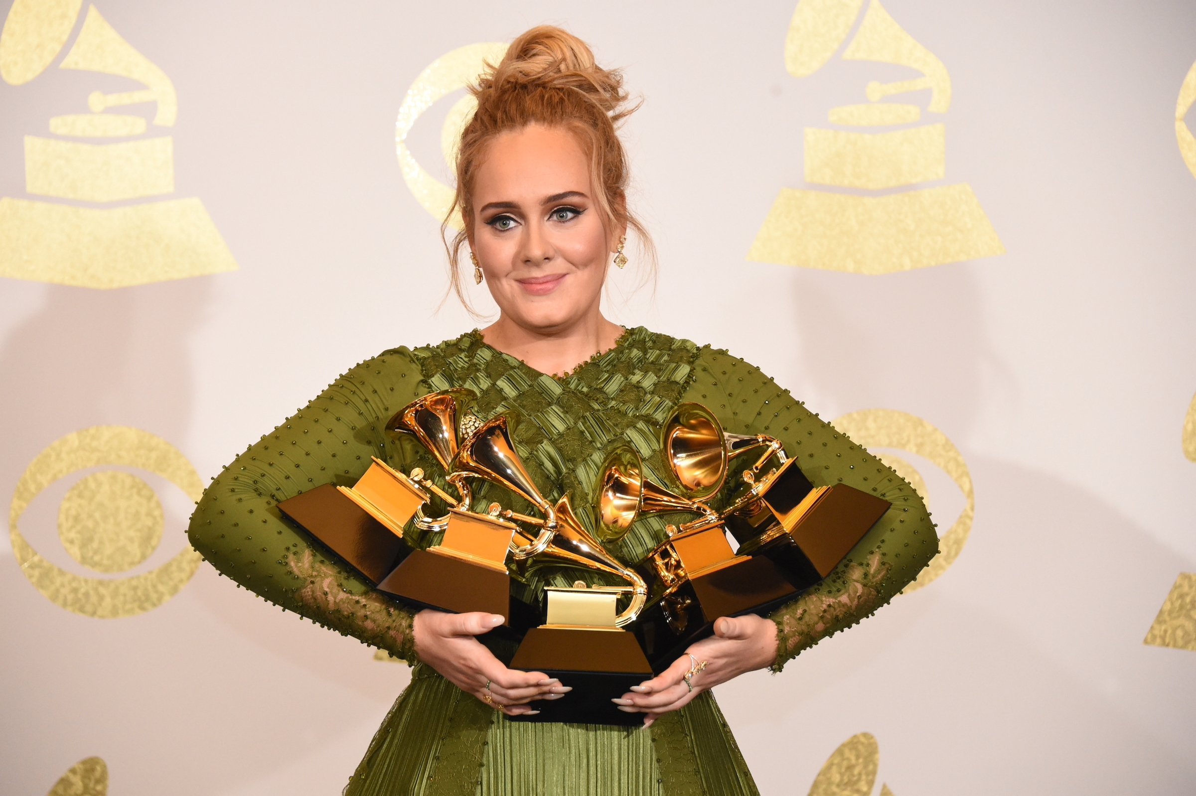Adele poses for photographs backstage at the Grammy Awards