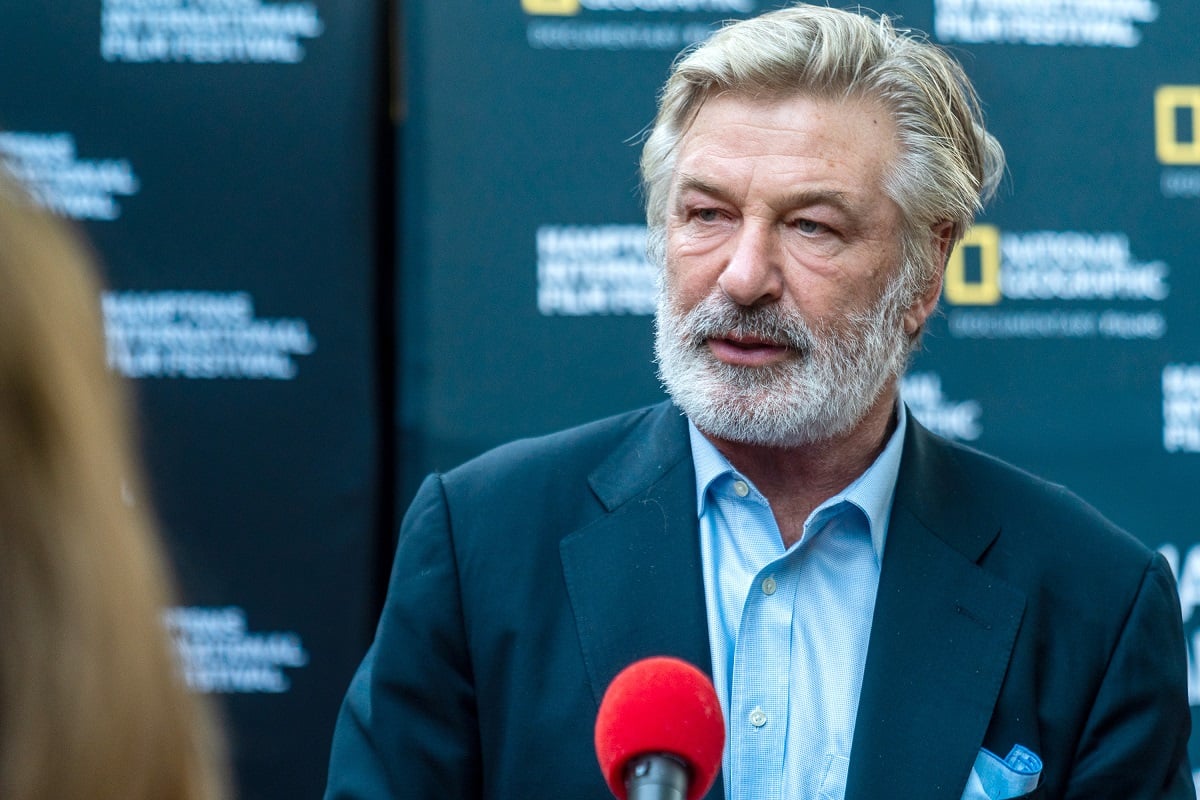 Alec Baldwin with a mustache and beard about to speak