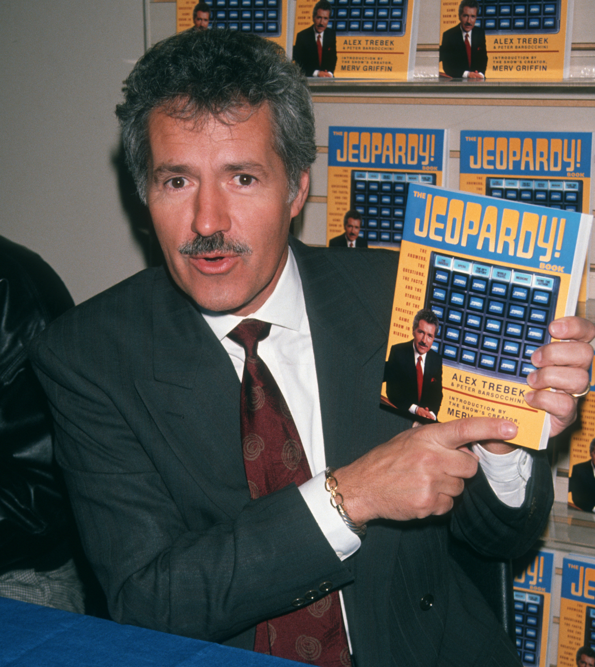 'Jeopardy!' host Alex Trebek sporting his trademark mustache while signing copies of 'The Jeopardy Book' in 1990