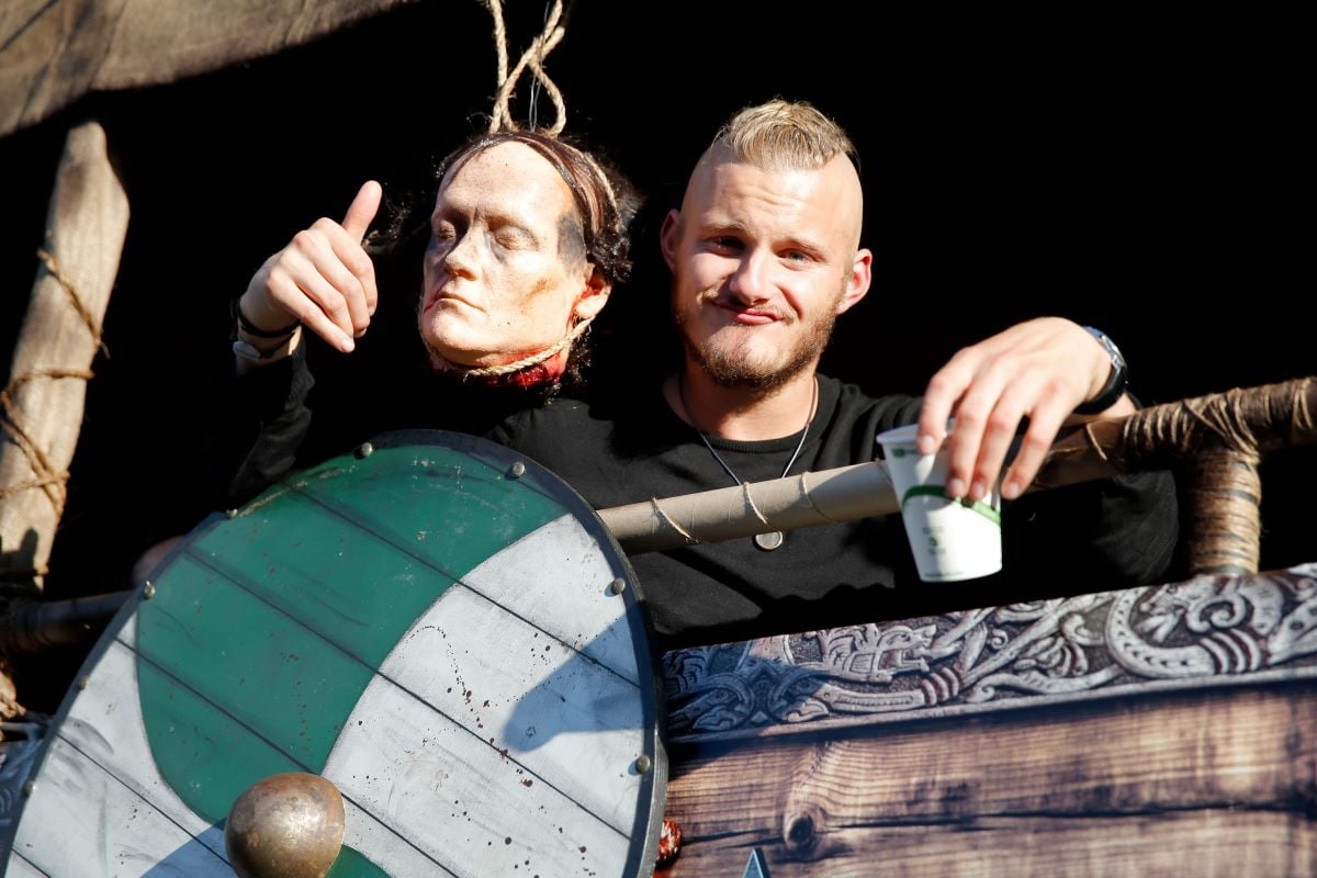 Alexander Ludwig poses with a prop head while holding a cup