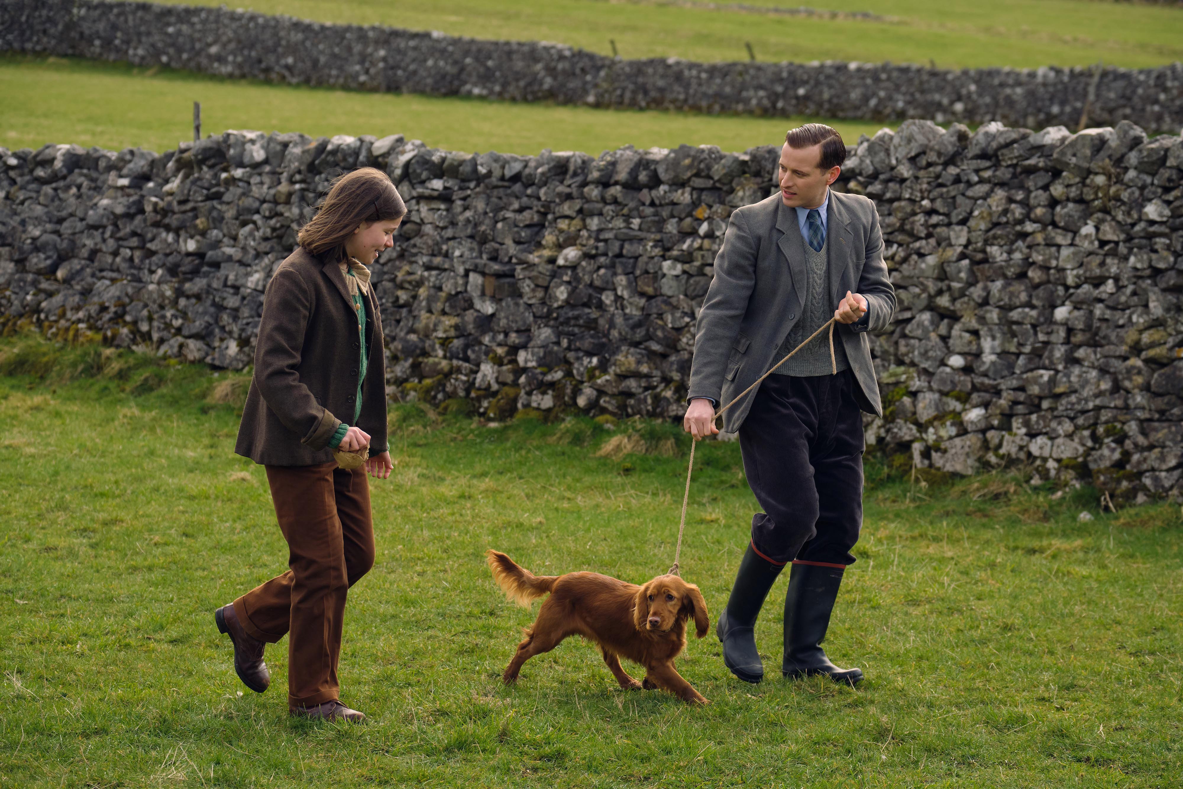 Helen and James, with a dog on a leash, in a scene from 'All Creatures Great and Small' Season 2