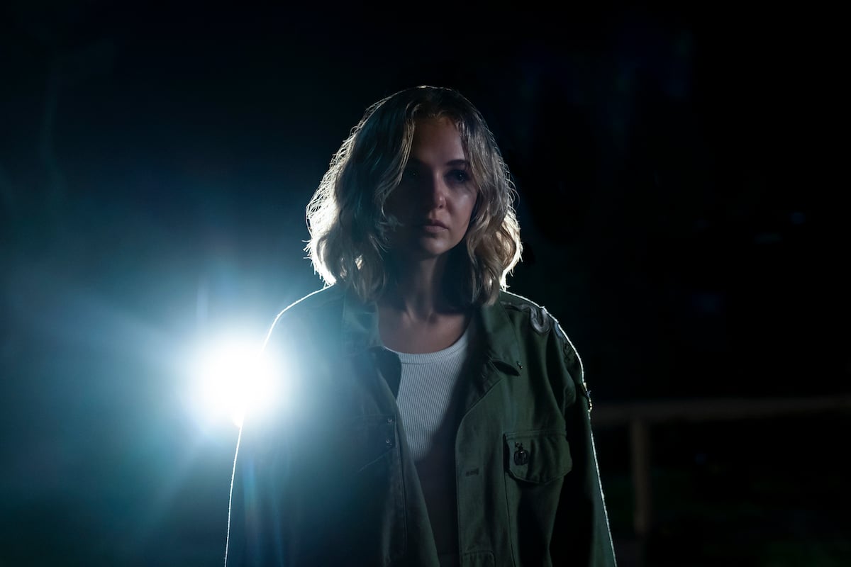 Allison (Madison Iseman) standing in dark with light behind her in 'I Know What You Did Last Summer'