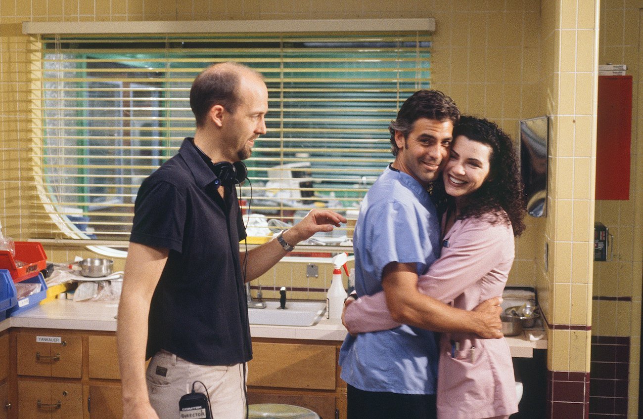 Anthony Edwards wears a black shirt as he stands next to George Clooney and Julianna Margulies as they embrace