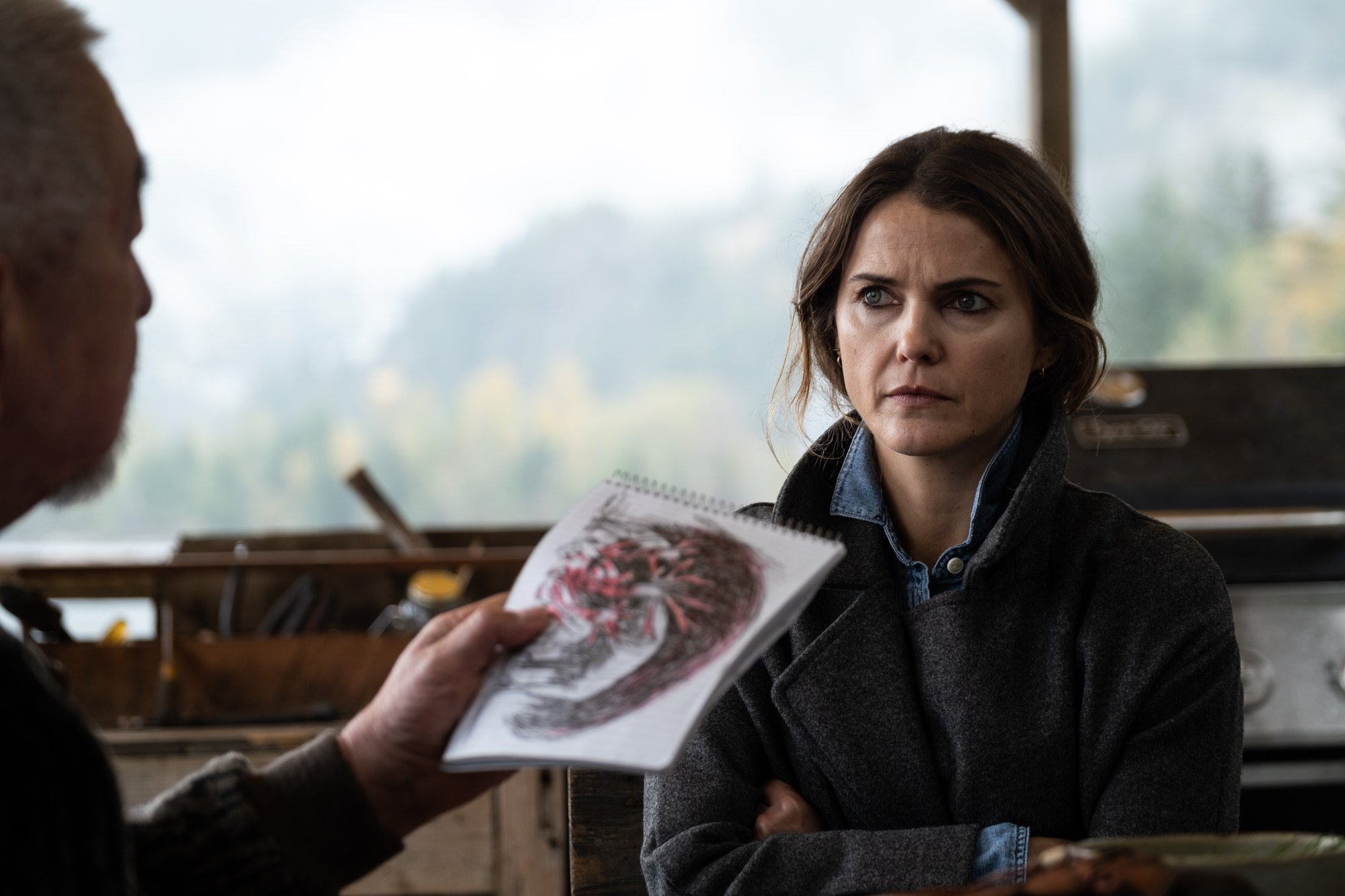 'Antlers' actor Keri Russell with her arms crossed sitting across from drawing
