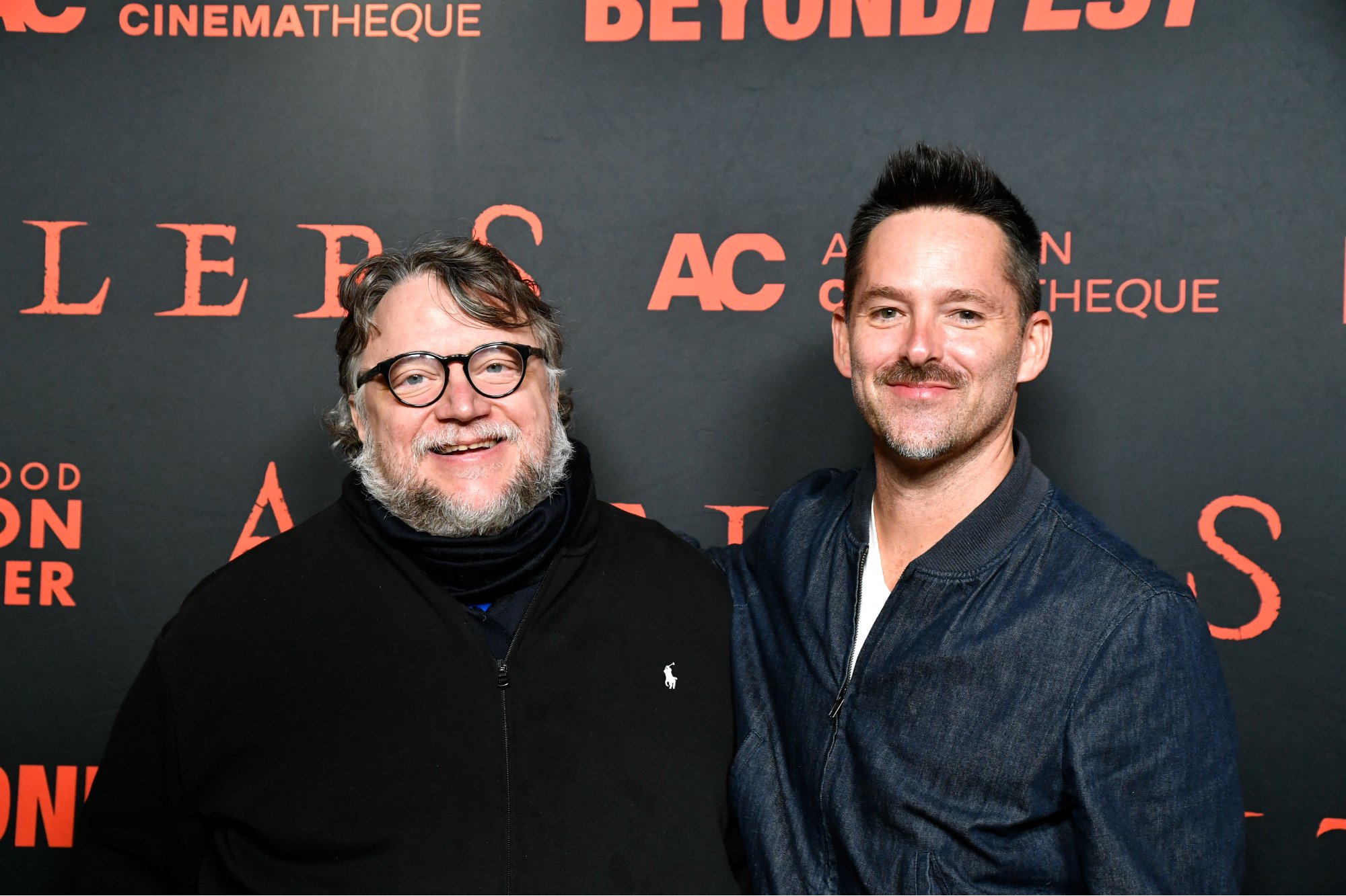 'Antlers' producer Guillermo del Toro and director Scott Cooper smiling in front of a step and repeat
