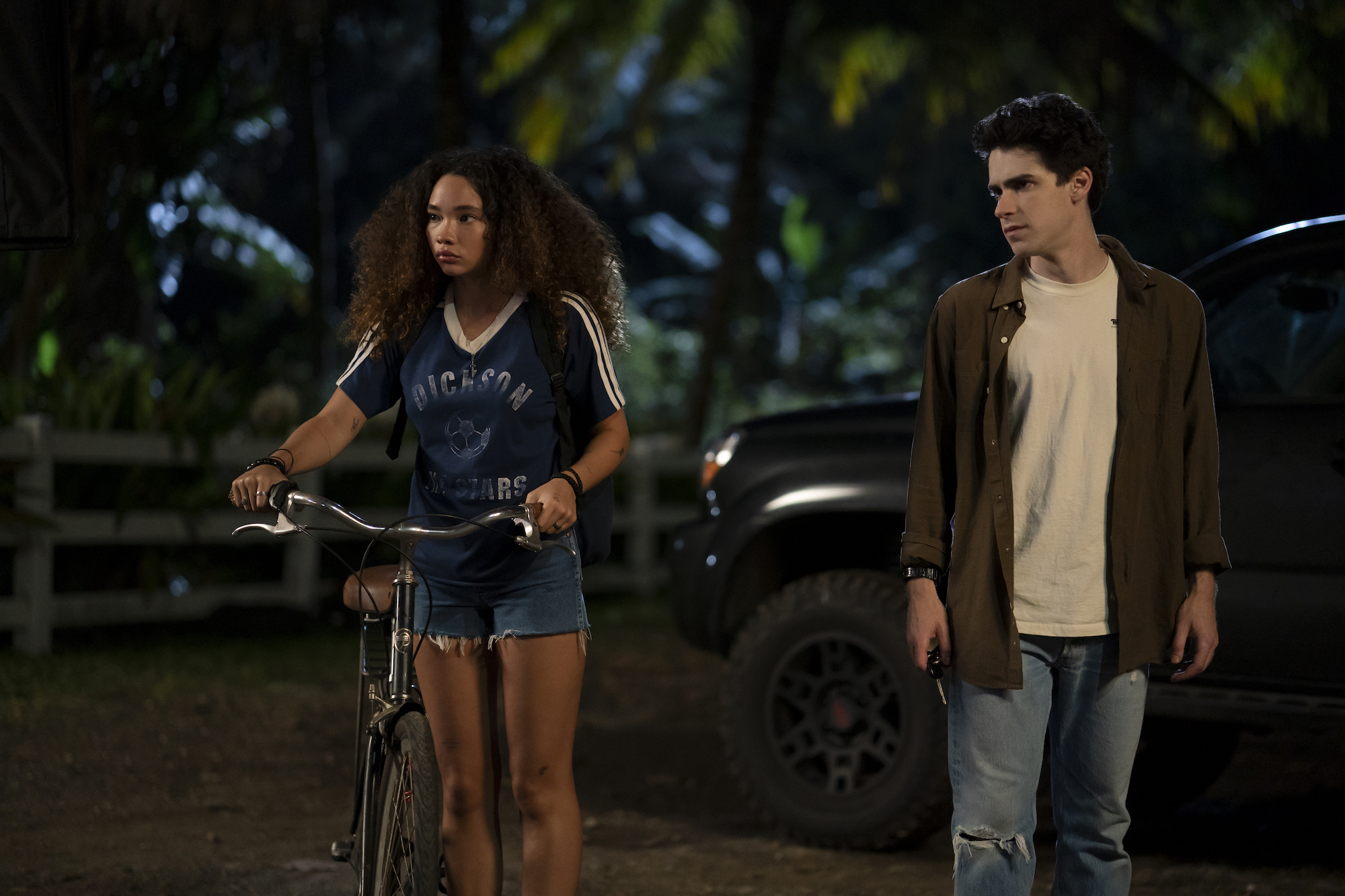 Ashley Moore rides her bike and Ezekiel Goodman walks in horror series I Know What You Did Last Summer