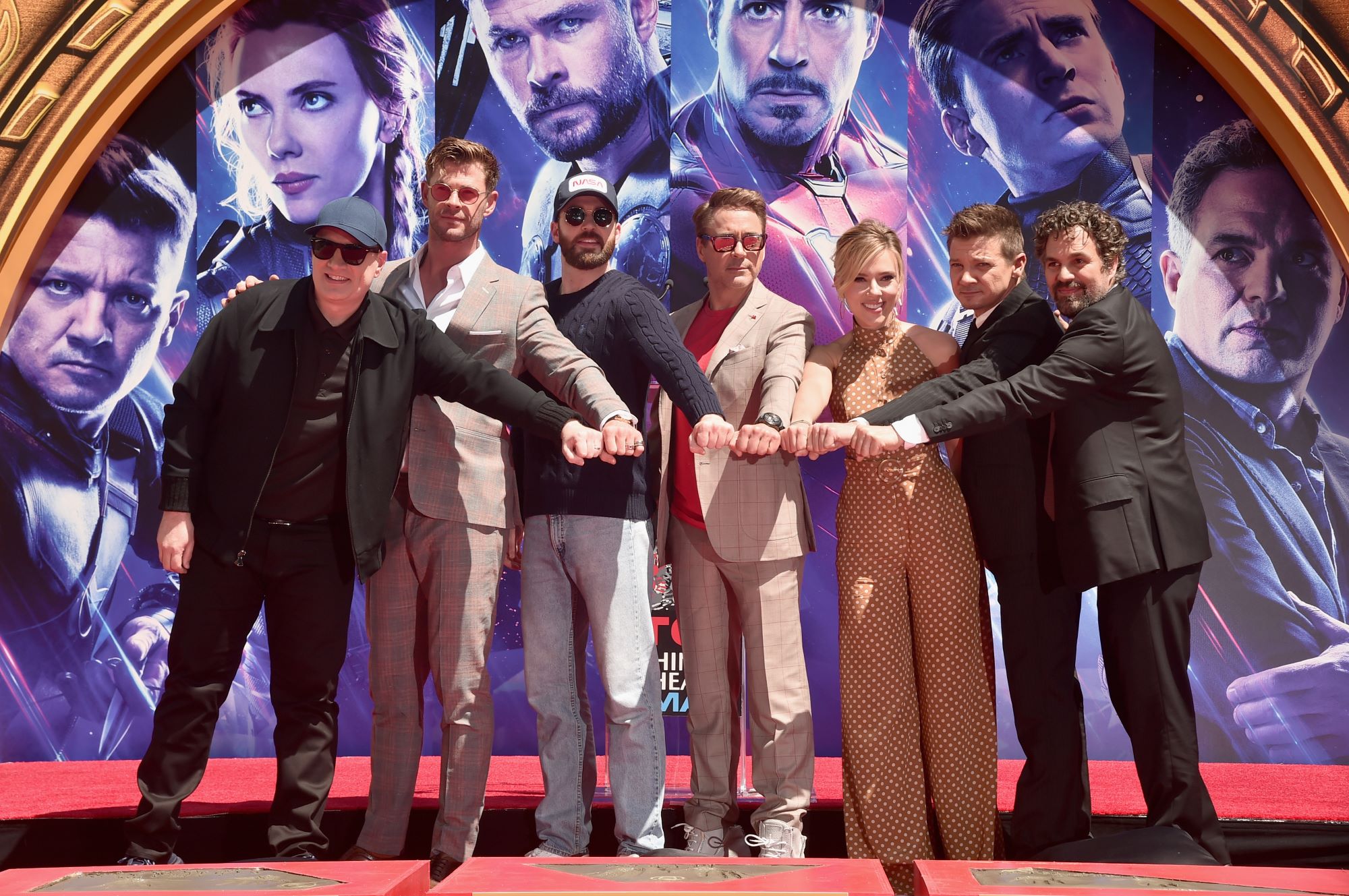 President of Marvel Studios Kevin Feige and 'Avengers: Endgame' stars Chris Hemsworth, Chris Evans, Robert Downey Jr., Scarlett Johansson, Jeremy Renner, and Mark Ruffalo bring their fists together and pose for pictures in front of their character posters for the movie.