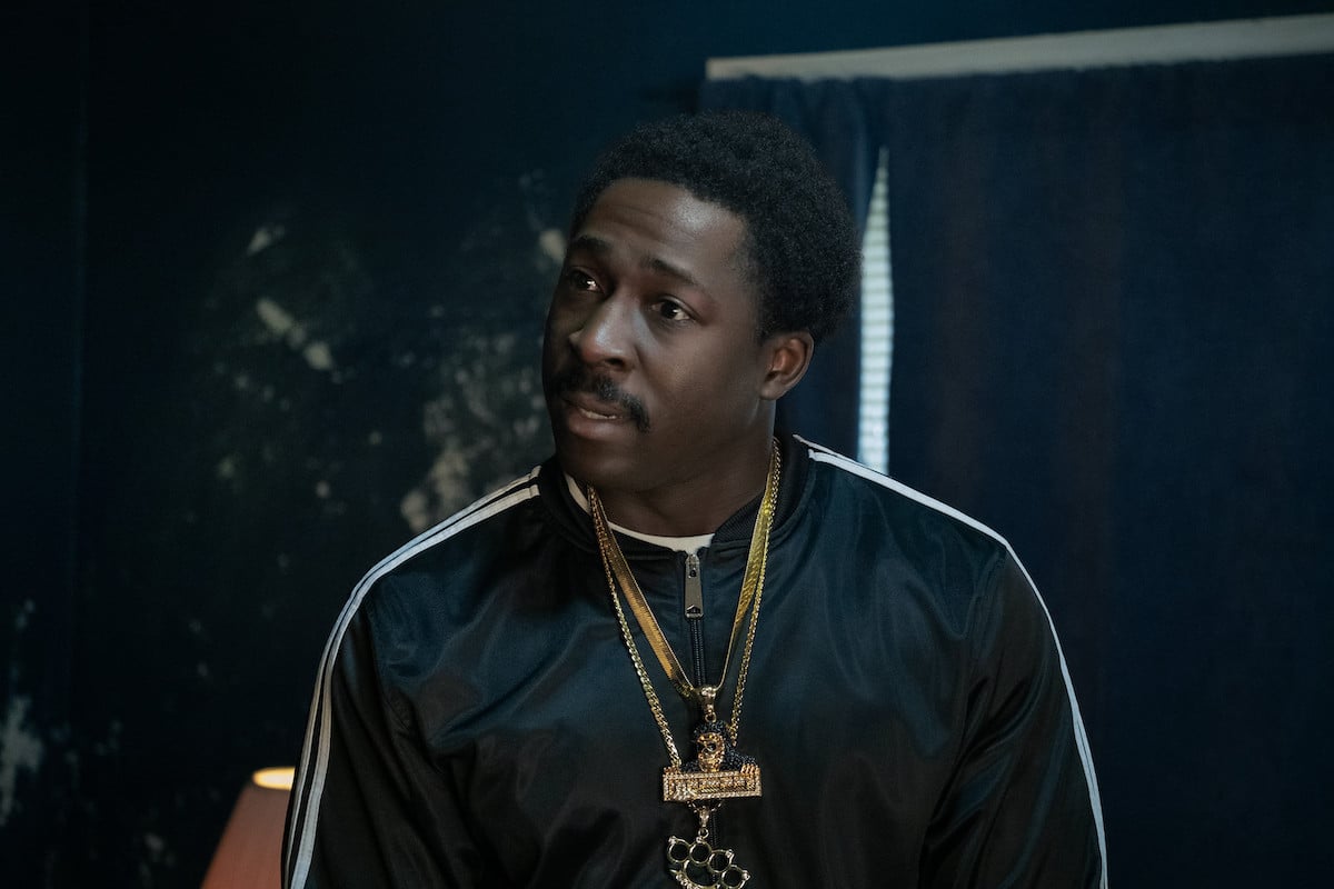 Eric Kofi-Abrefa wearing a track jacket and gold chains on 'BMF' as Lamar.