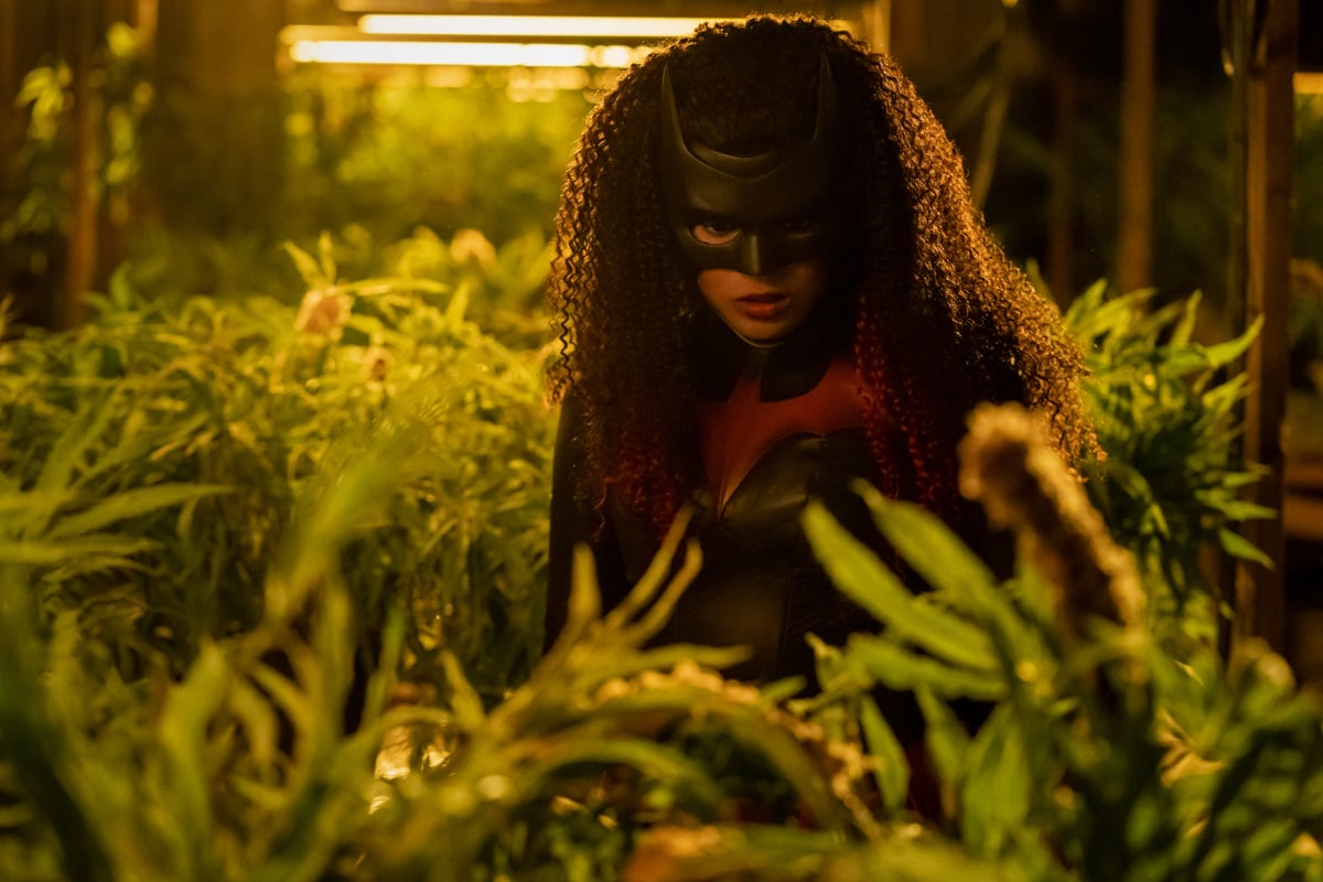 'Batwoman' actor Javicia Leslie, in character as Ryan Wilder, wears her Batwoman costume and is surrounded by plants.
