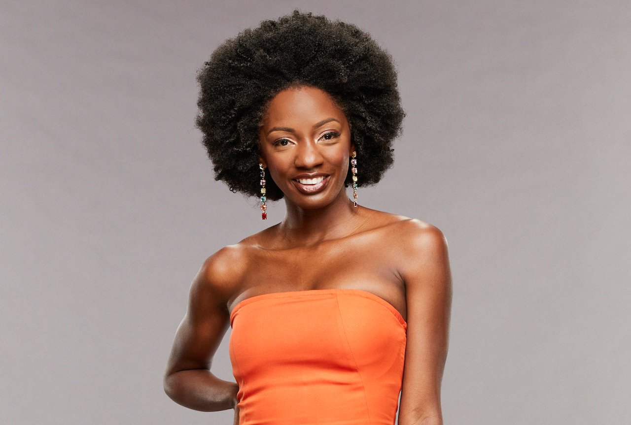 Azah Awasum on 'Big Brother 23' smiles in an orange dress.