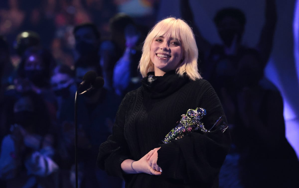 Billie Eilish smiles and holds an award.