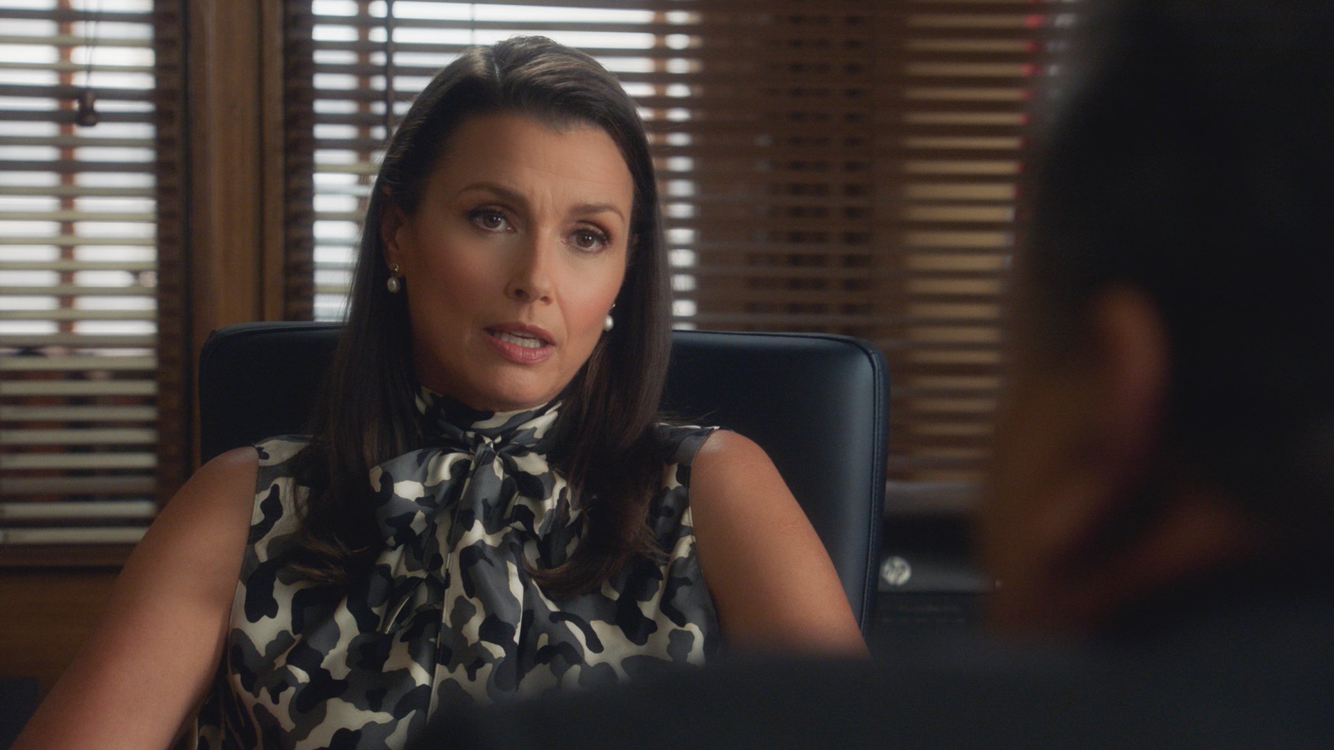 Bridget Moynahan as Erin Reagan on 'Blue Bloods' sits at her desk talking to Anthony.