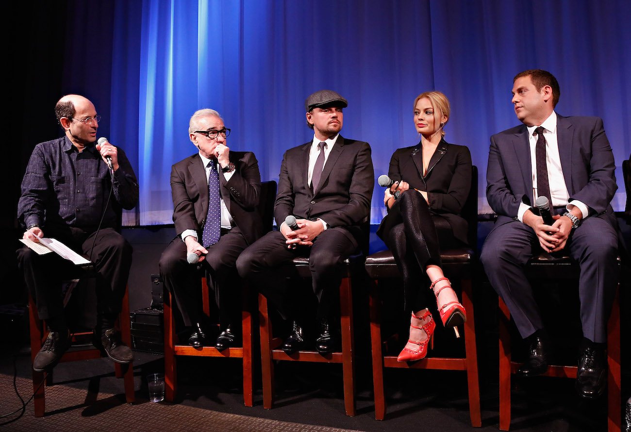 Brian Rose, Martin Scorsese, Leonardo DiCaprio, Margot Robbie, and Jonah Hill sit on stools and look on