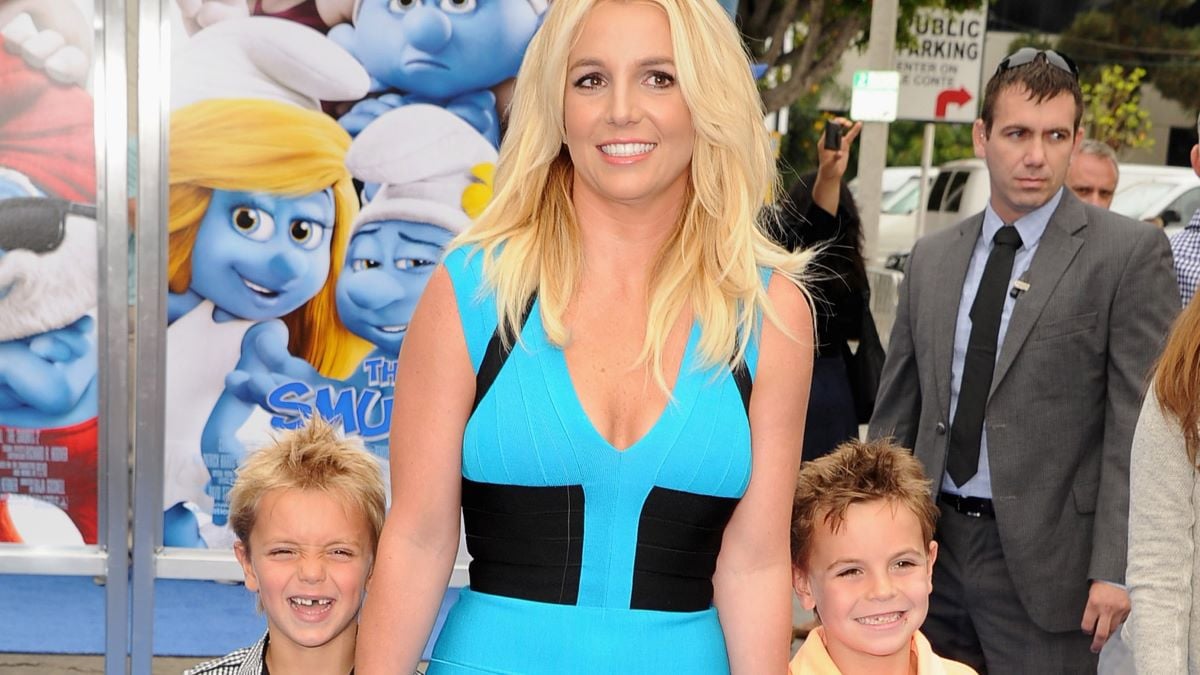 Britney Spears smiles in a blue dress in between her young sons