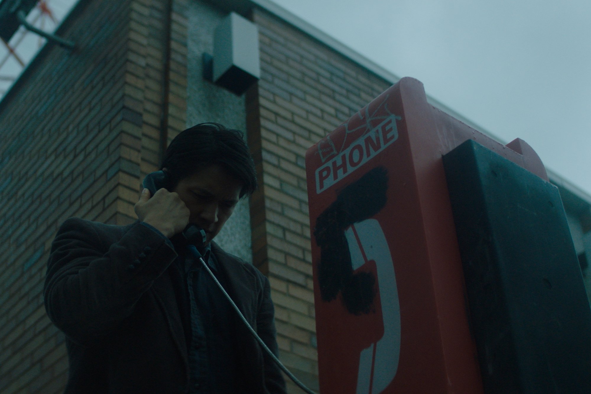 'Broadcast Signal Intrusion' actor Henry Shum Jr. at payphone outside