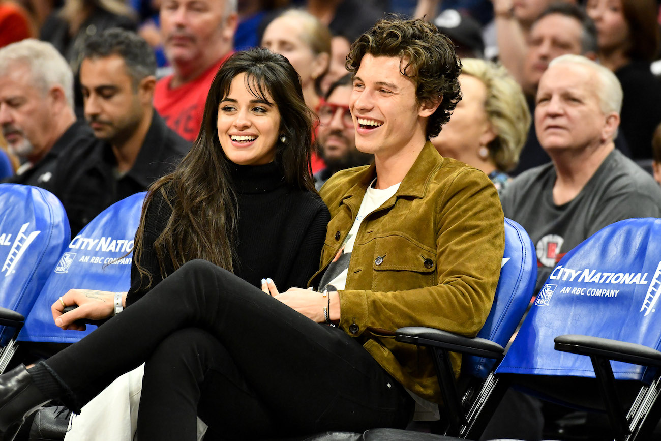 Camila Cabello and Shawn Mendes smile as they sit next to each other at a Clippers game