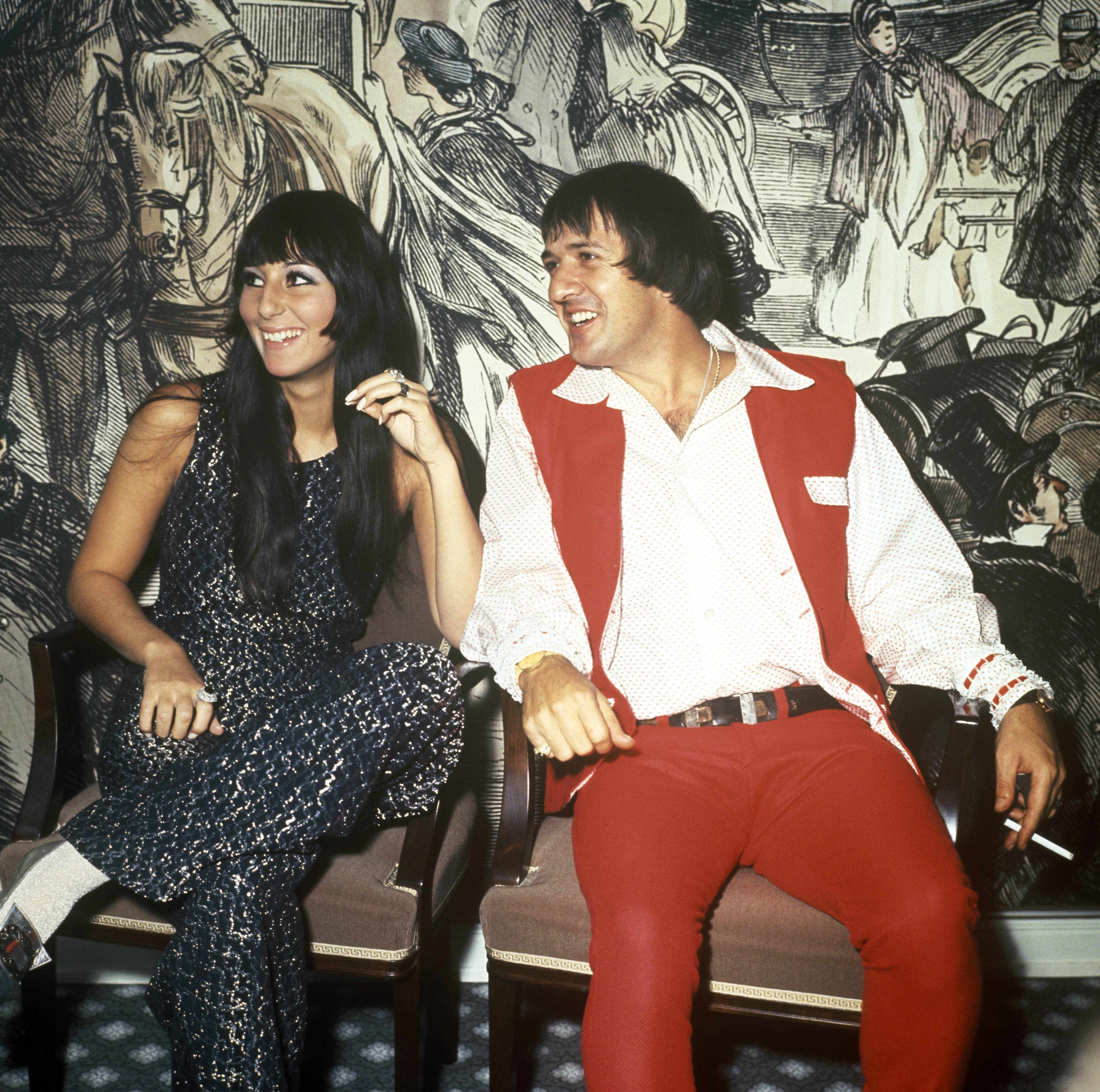 Cher in a black dress and Sonny Bono in a red vest and pants.