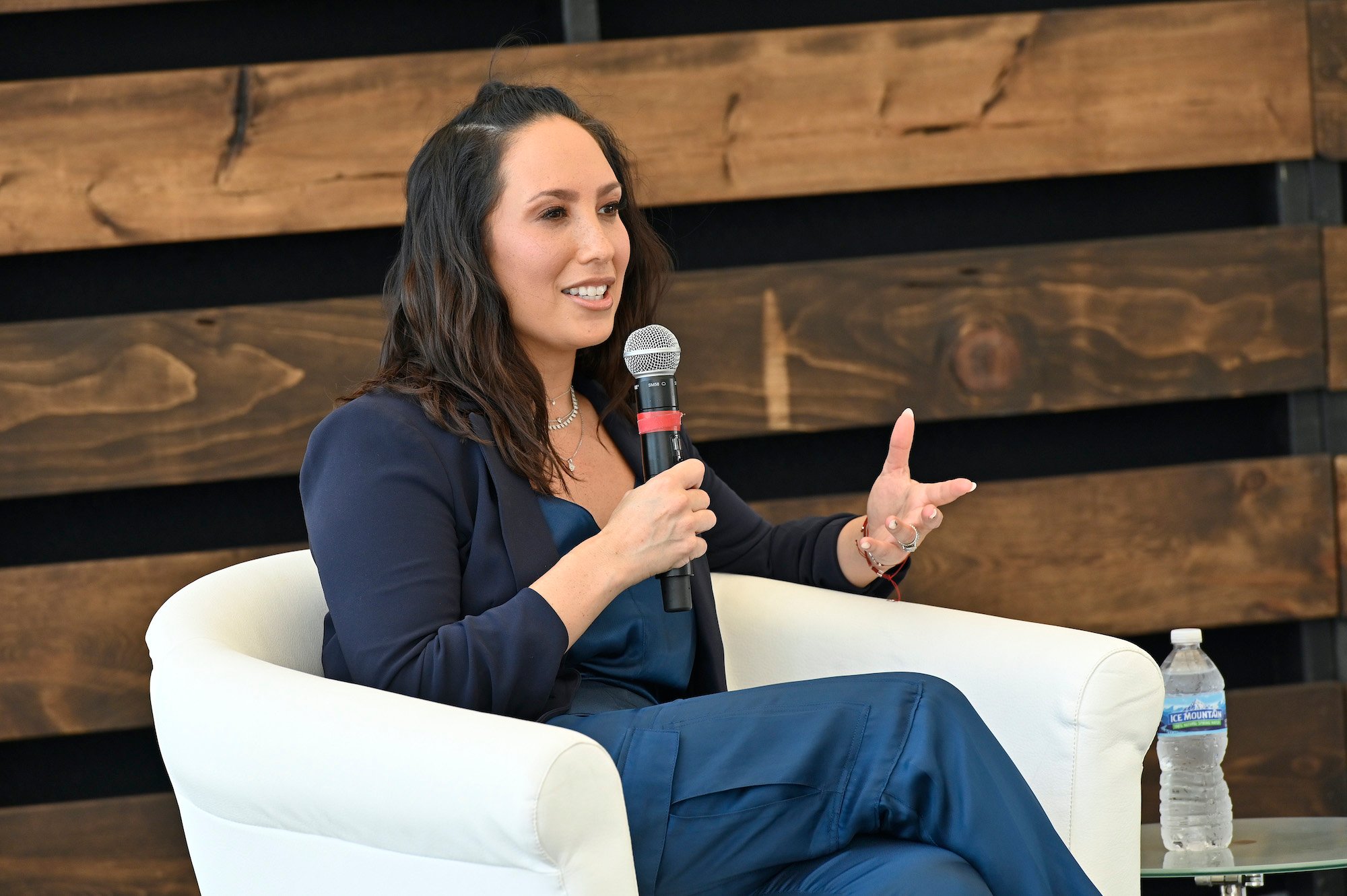 'Dancing with the Stars' pro Cheryl Burke seated and holding a microphone and speaks to an audience