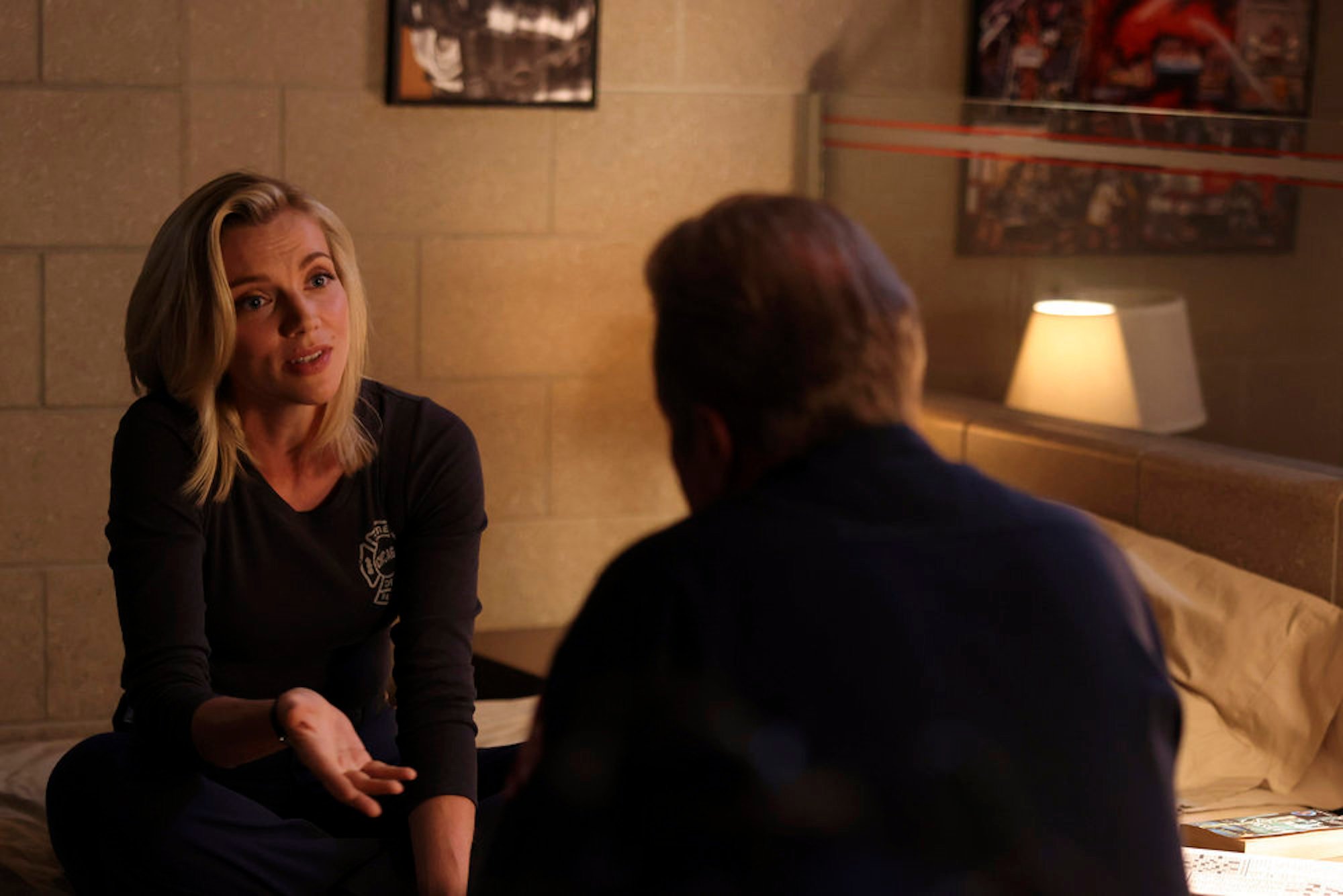 Sylvie Brett talking to someone in a dimly lit room in 'Chicago Fire' Season 10. Sylvie Brett and Matt Casey begin a long-distance relationship this season.
