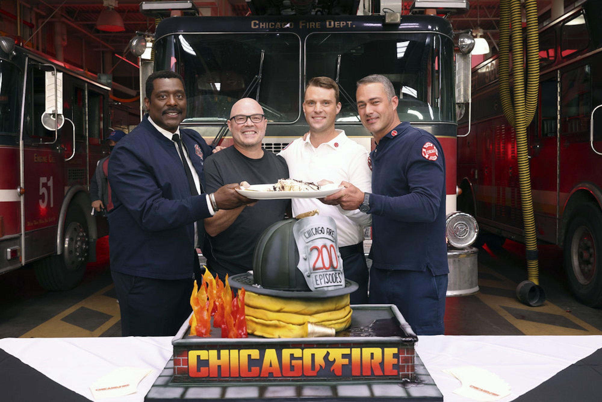 Eamonn Walker, Derek Haas, Jesse Spencer, and Taylor Kinney from the 'Chicago Fire' cast smiling and celebrating 'Chicago Fire' episode 200