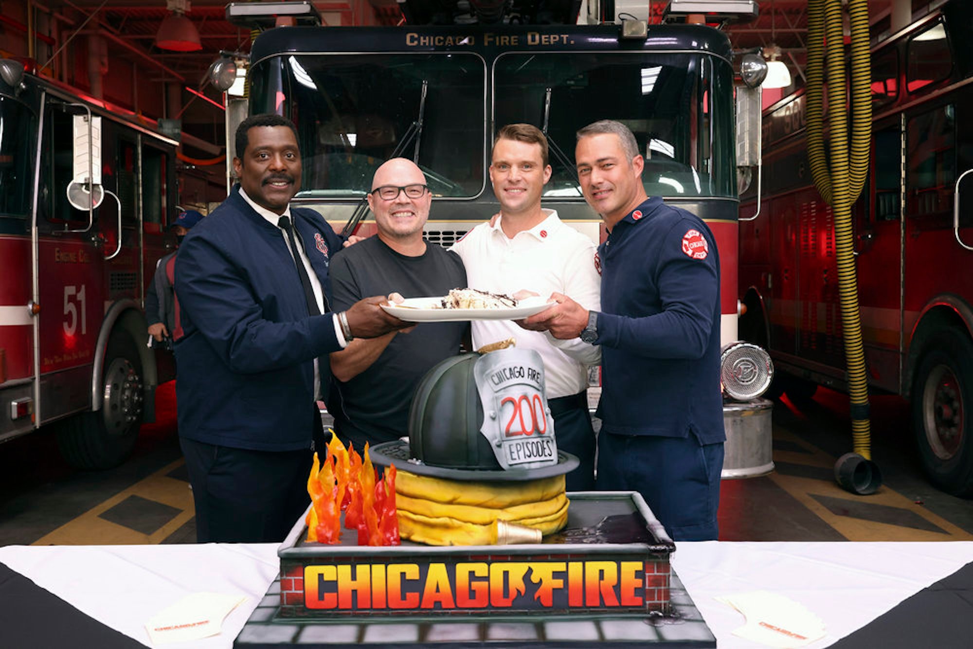 Eamonn Walker, Derek Haas, Jesse Spencer, and Taylor Kinney from the 'Chicago Fire' cast smiling and celebrating 'Chicago Fire' episode 200