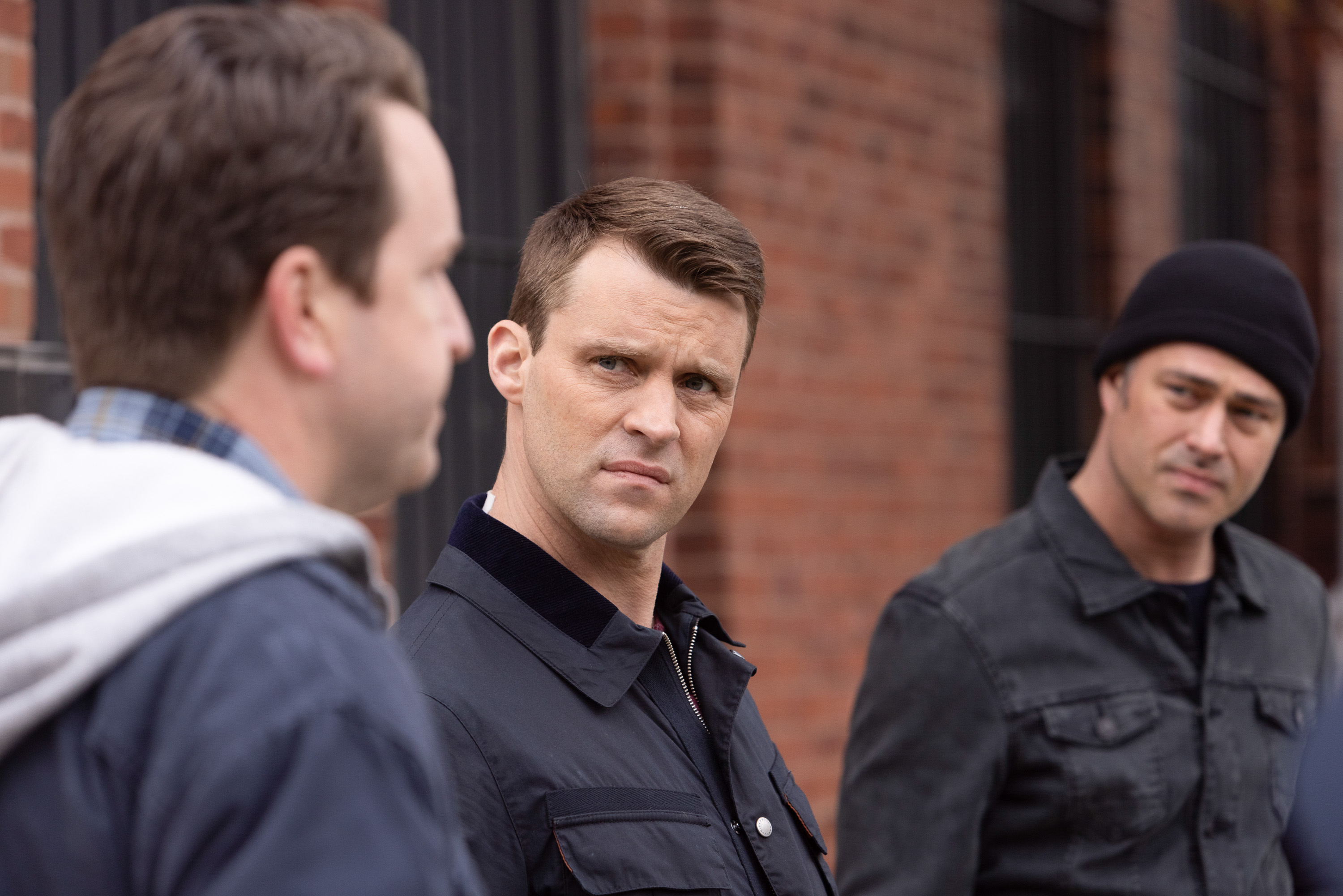 Matt Casey (Jesse Spencer) and Severide (Taylor Kinney) looking at another man In 'Chicago Fire'