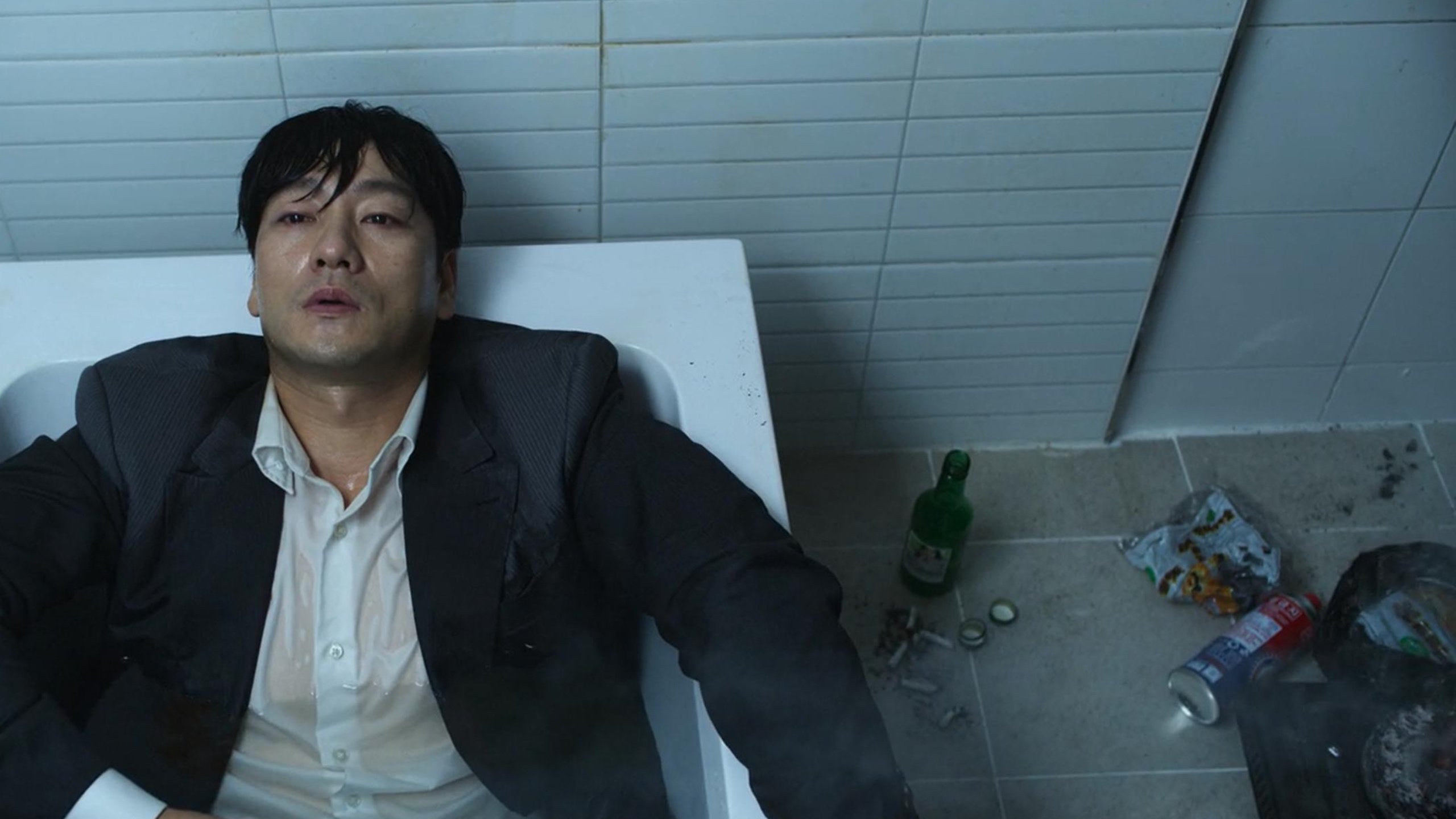 Cho Sang-woo in bathtub scene 'Squid Game' episode 2 wearing grey suit