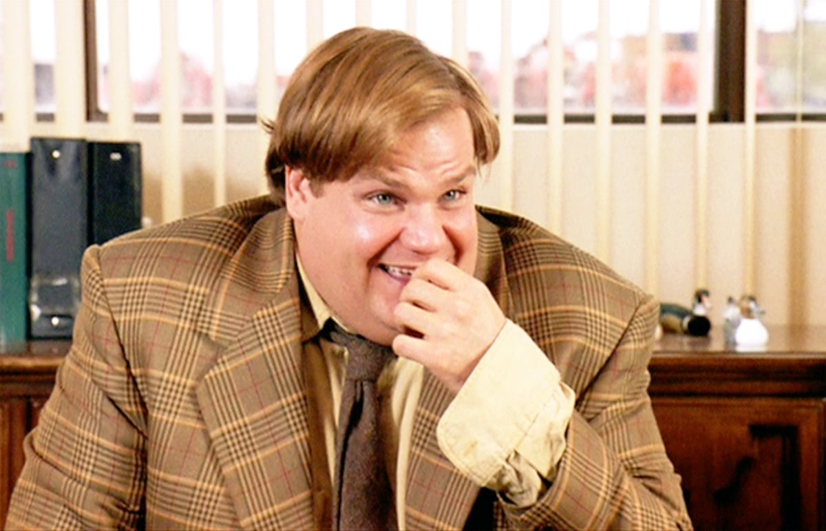 Chris Farley as Tommy Callahan in 'Tommy Boy' laughing, sitting at a desk