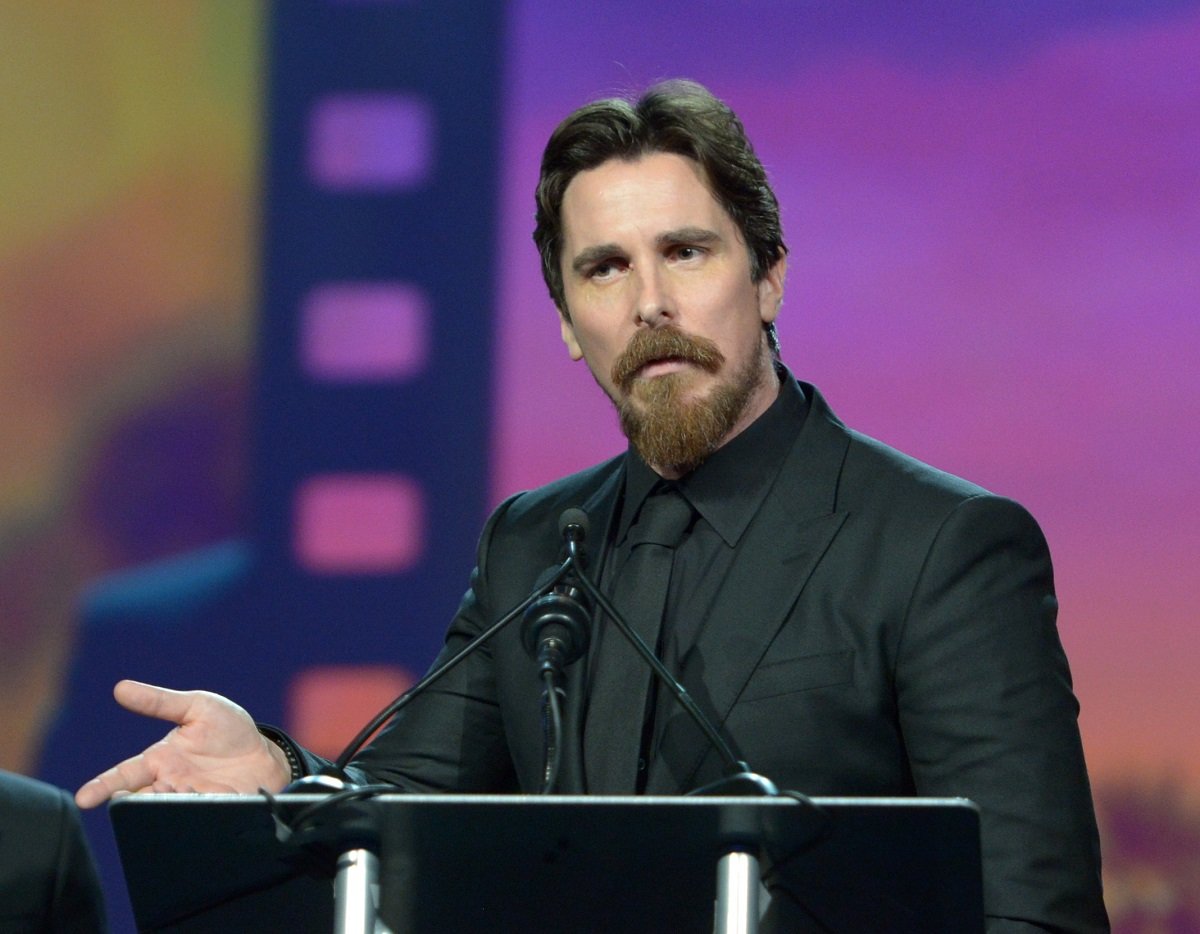 Christian Bale on stage in a black suit