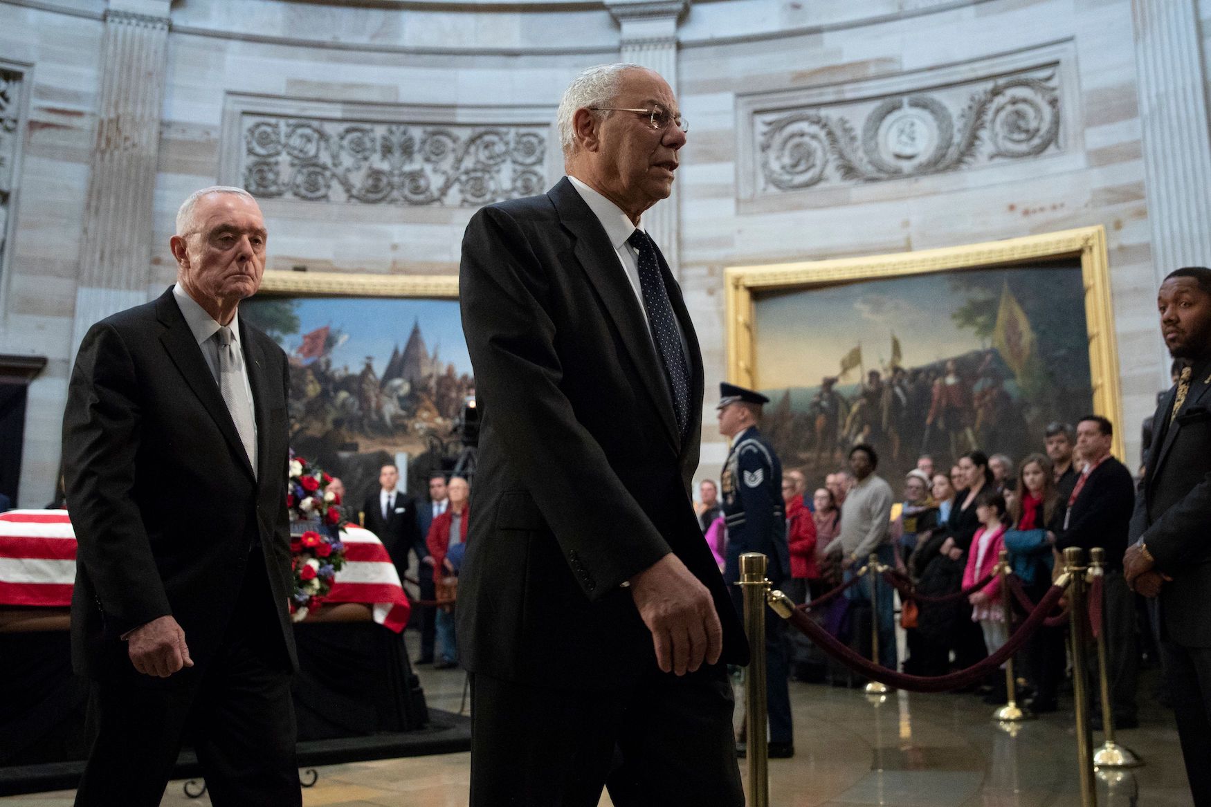 Colin Powell walking through a crowd to memorialize George H.W. Bush
