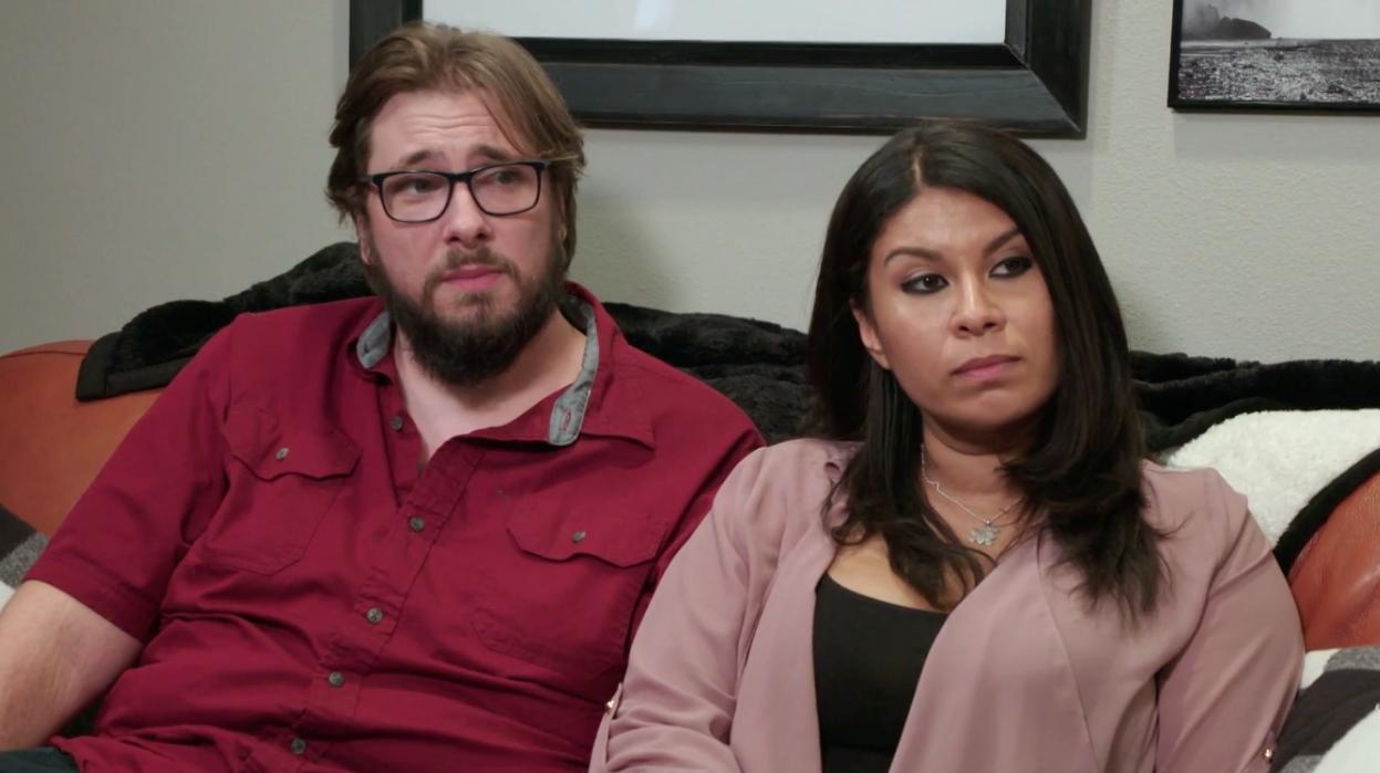 Colt Johnson and Vanessa Guerra sitting on a couch together looking sad on '90 Day: The Singe Life' Season 1