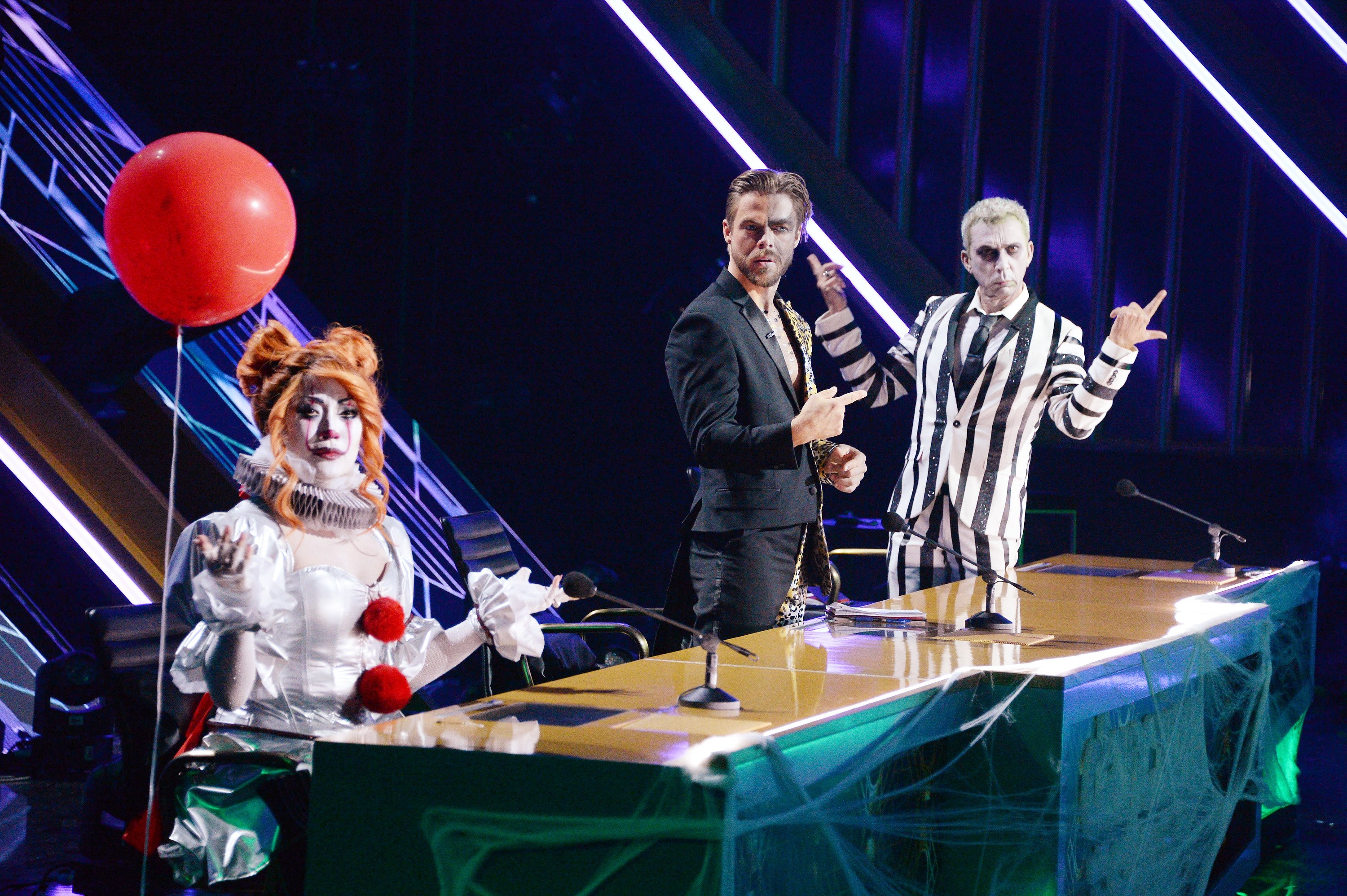 Carrie Ann Inaba in an 'IT' costume sitting at the judges panel with Derek Hough and Bruno Tonioli during the season 29 Horror Night on 'Dancing with the Stars'