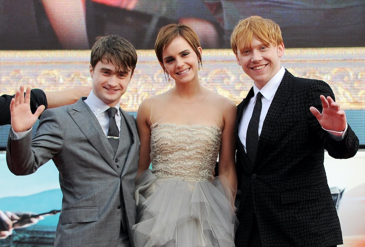Harry Potter cast members Daniel Radcliffe, Emma Watson and Rupert Grint wave at a premiere
