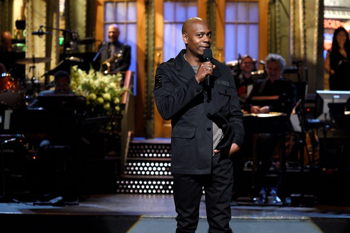 Dave Chappelle on SNL stage in a black jacket