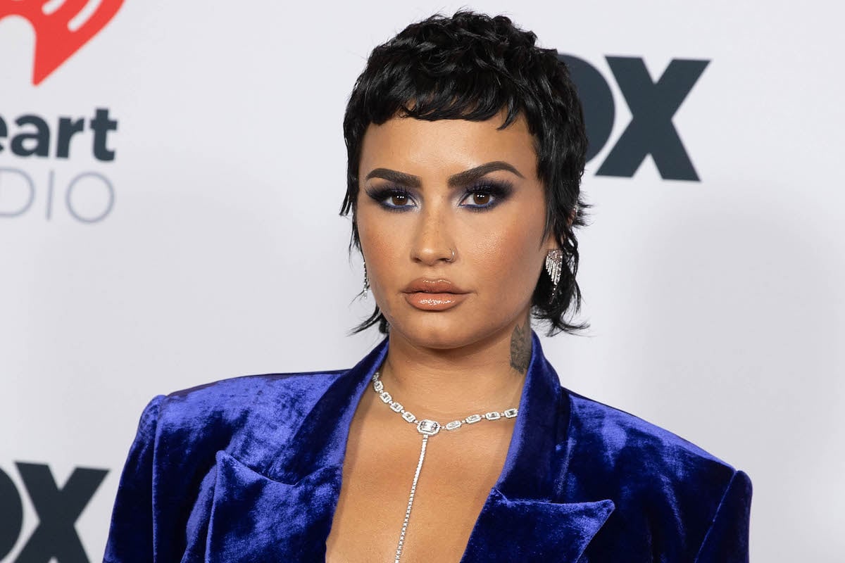Demi Lovato wears a blue velvet blazer at an event.