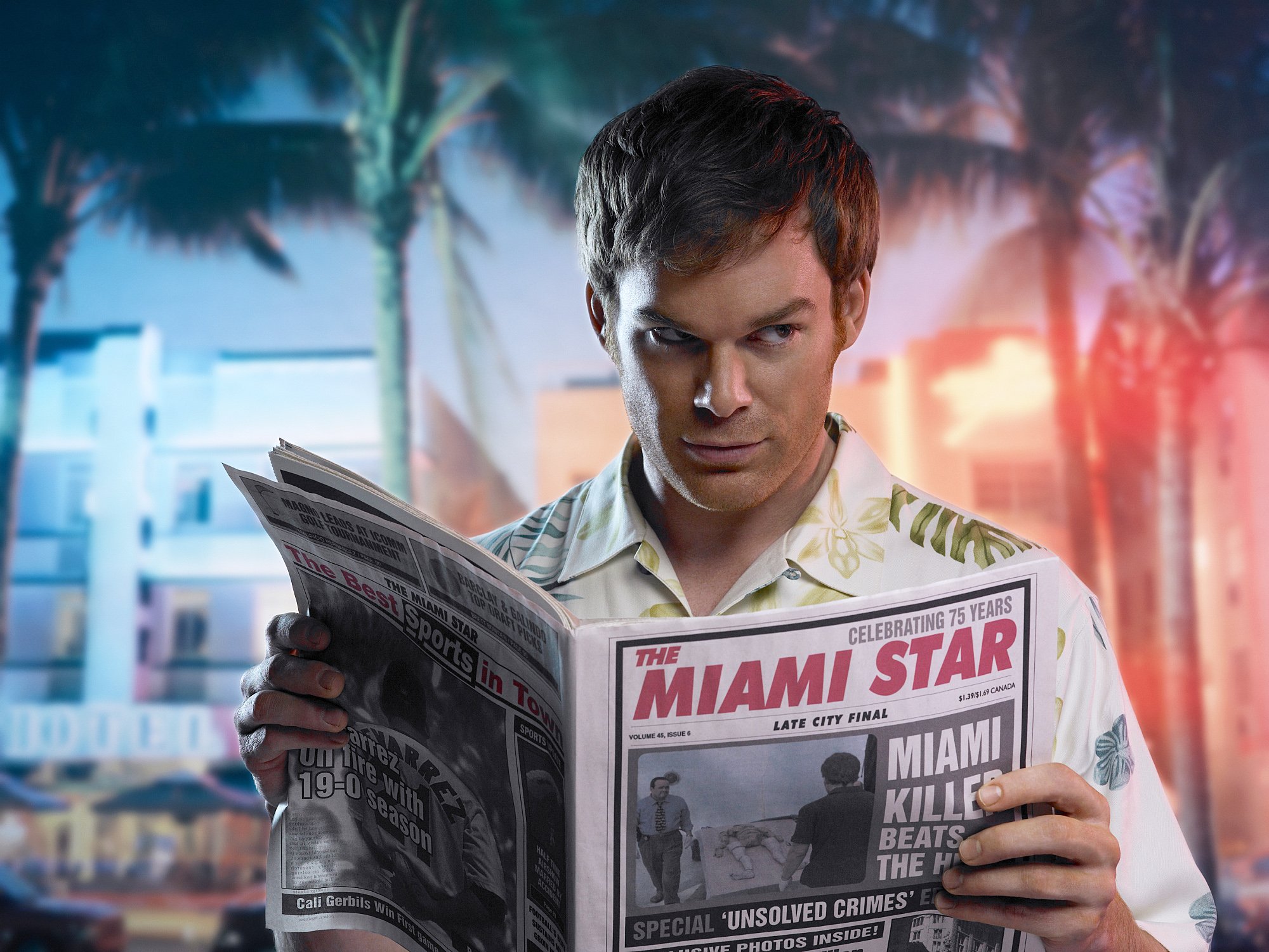 Dexter Morgan reads a newspaper while police car lights flash behind him.