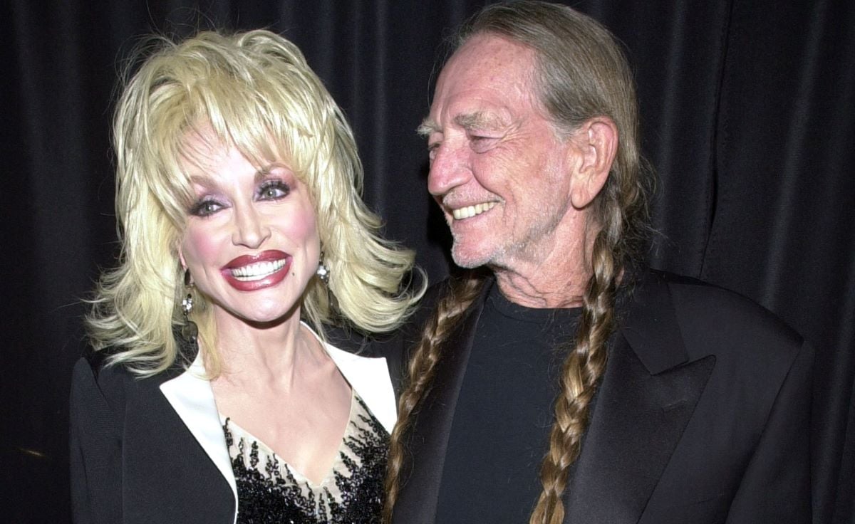 Dolly Parton on left, smiling in black and white, Willie Nelson on right, looking at Parton and smiling
